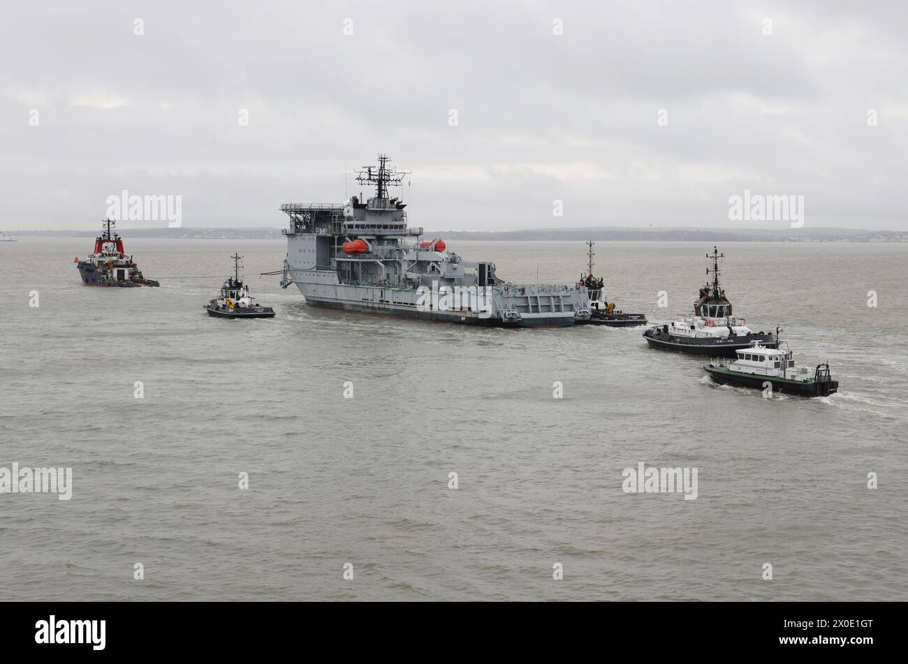 The former RFA DILIGENCE under tow by the ocean going tug HISPANIA and Serco vessels with the Admiralty pilot launch astern Stock Photo