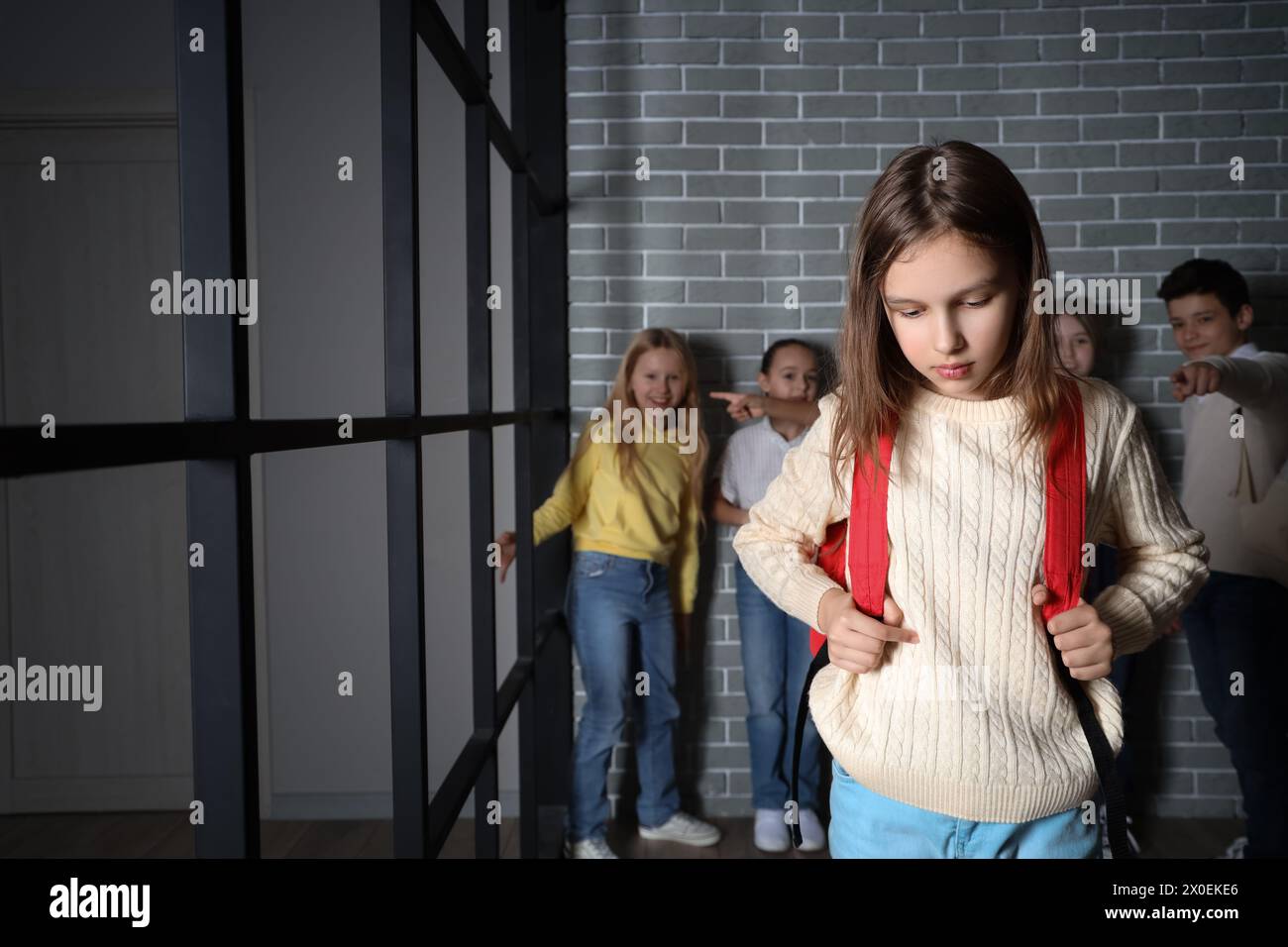 Bully Backpack Rocks Bullied little girl with backpack at school Stock Photo - Alamy