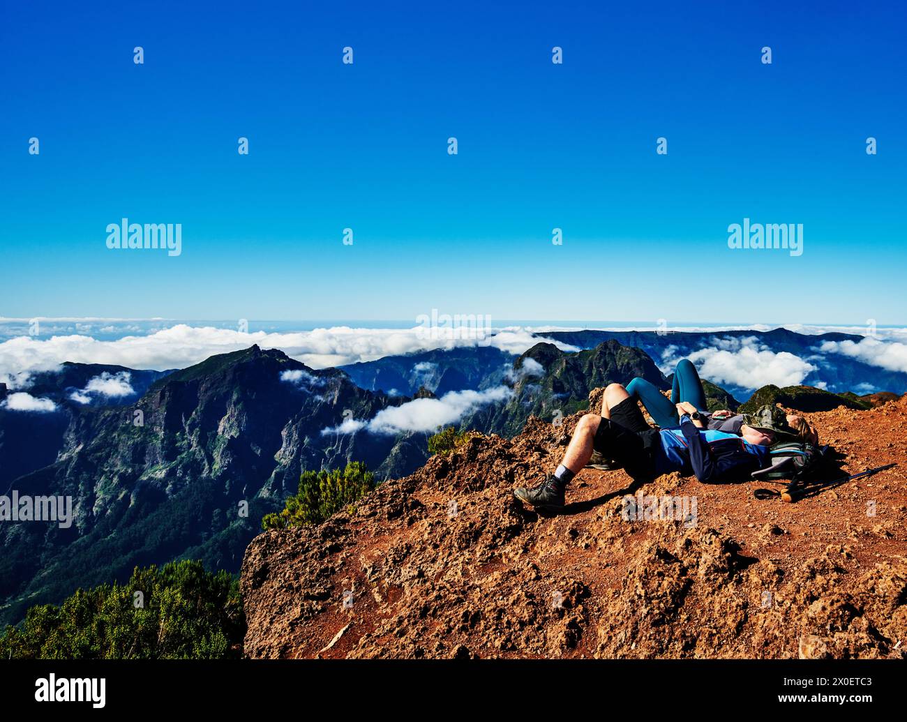 Hikers relaxing at the top of PR1 trail,  Pico do Arierio To Pico Ruivo Hike, On Madeira Island, Portugal, Europe Stock Photo