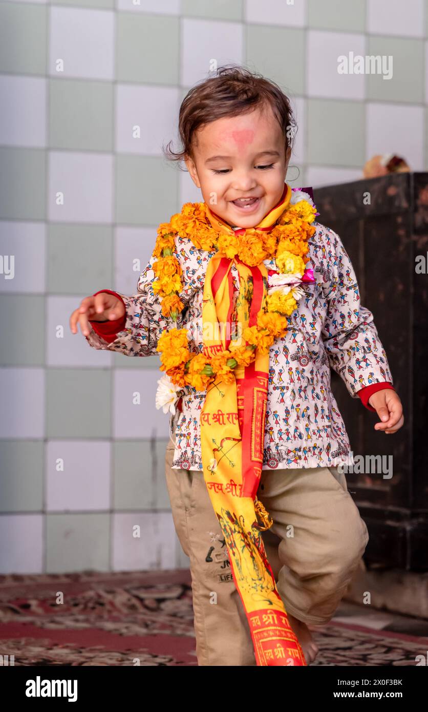 cute kid wearing holy garland at temple from flat angle Stock Photo