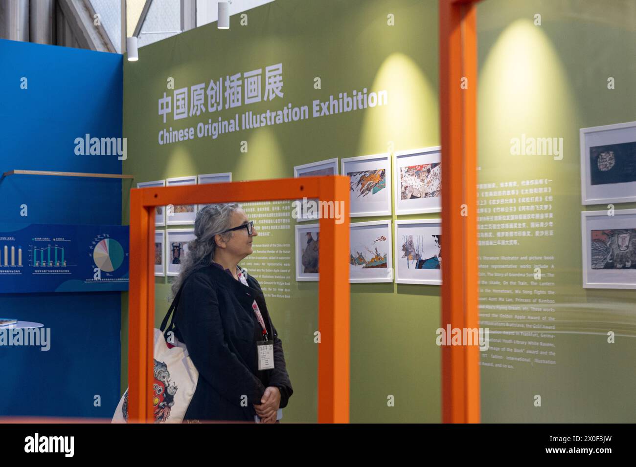 Bologna, Italy. 10th Apr, 2024. A woman visits 'Chinese Original Illustration Exhibition' area during the 61st Bologna Children's Book Fair held in Bologna, Italy, April 10, 2024. Original Chinese children's books have caught the attention of international visitors at the 61st Bologna Children's Book Fair this week. TO GO WITH 'Children's books boost Sino-Western cultural exchanges at int'l book fair' Credit: Li Jing/Xinhua/Alamy Live News Stock Photo