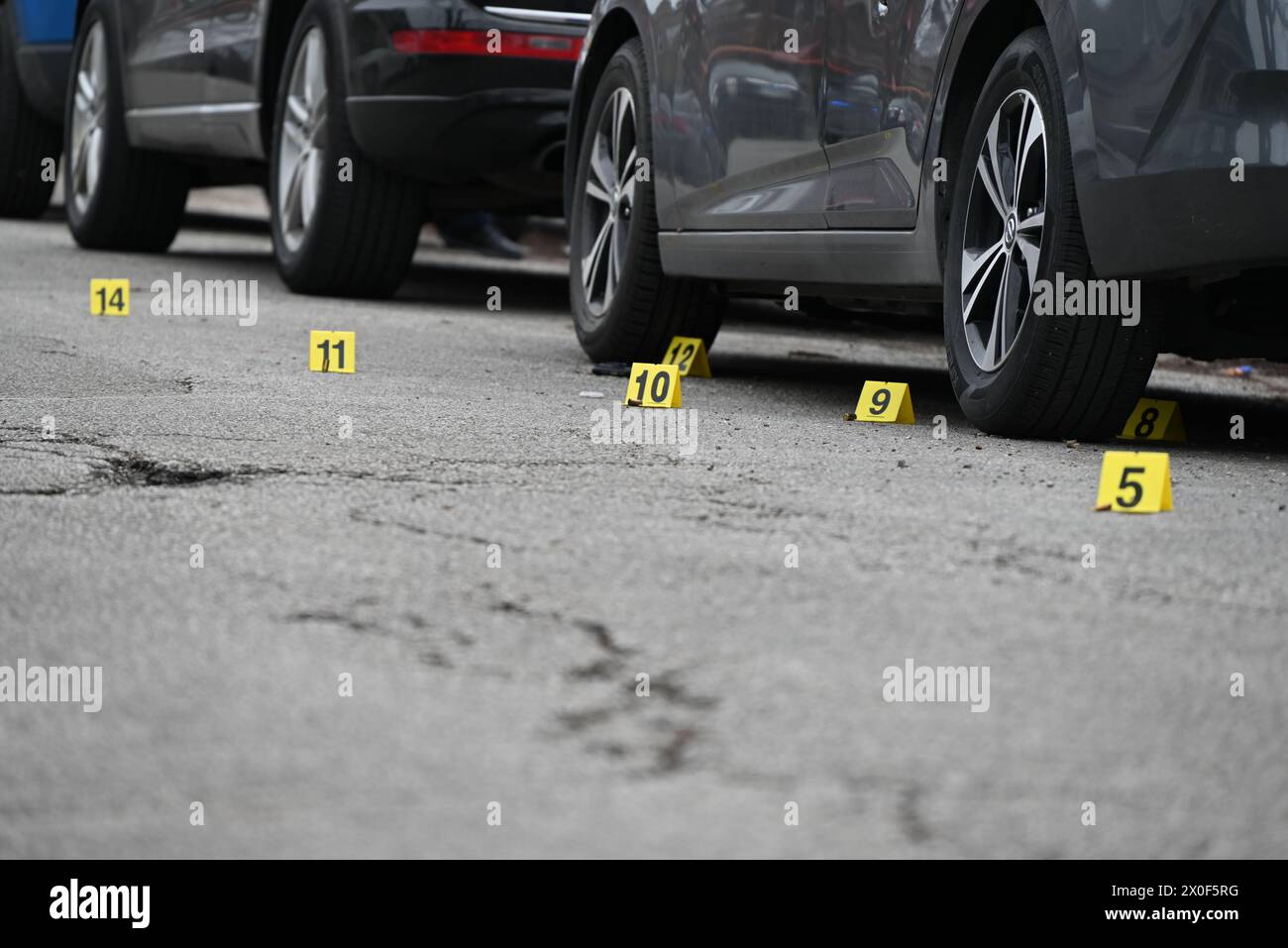 Shell casings discovered at the crime scene and marked by several evidence markers. 20-year-old male shot by another person and taken into custody by police in Chicago, Illinois, United States on April 11, 2024. Thursday afternoon at approximately 2:17 p.m. in the 1500 block of N. Leclaire Avenue, a 20-year-old male victim was discovered to have sustained one gunshot wound to his right leg after being involved in an exchange of gunfire with an unknown individual. The victim was transported to the hospital in good condition and the victim was placed in custody. Detectives are Investigating and Stock Photo