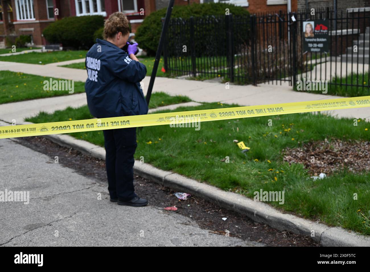 Chicago police officer takes photos of shell casings on the ground, a ...