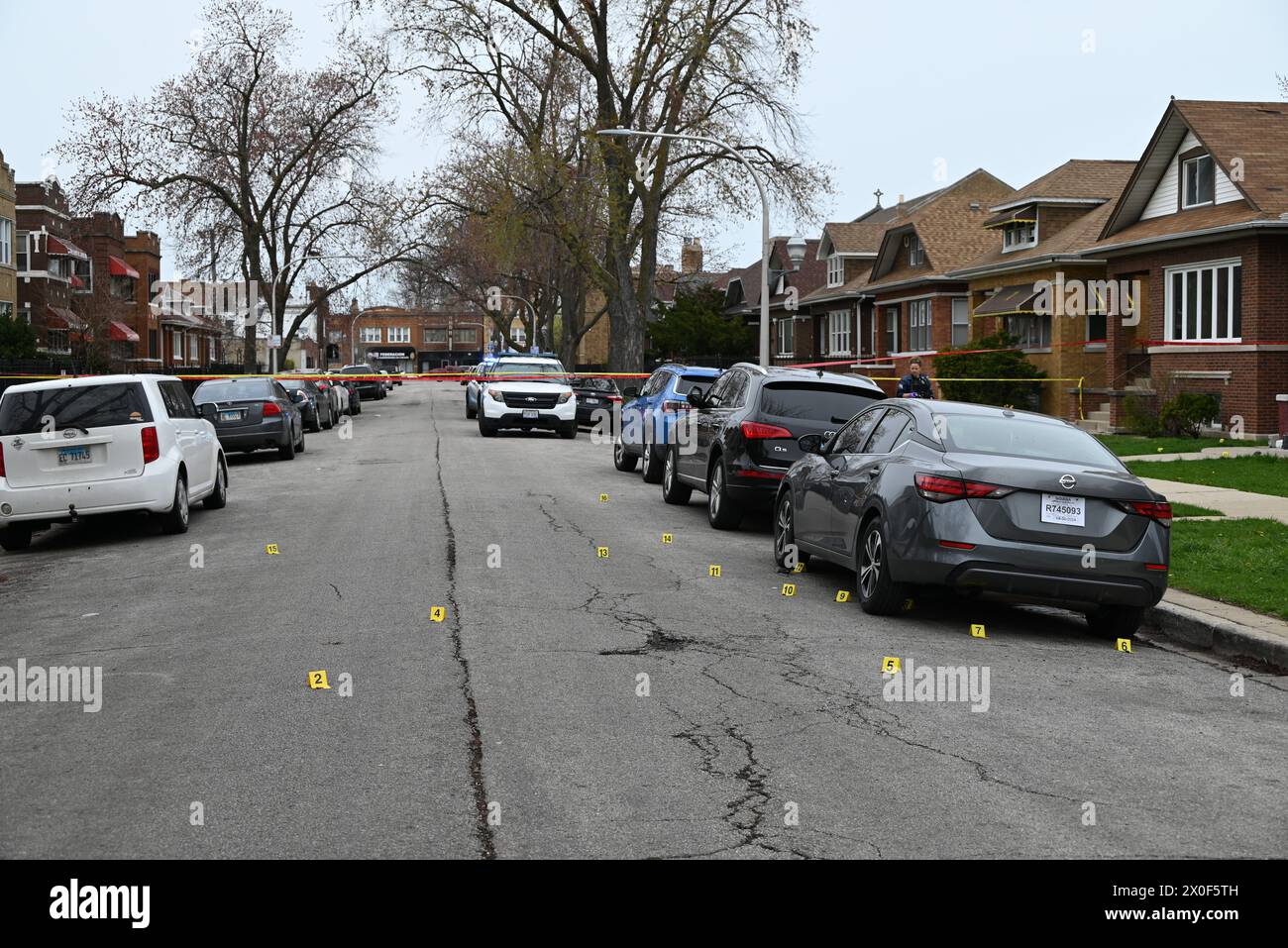 Shell casings discovered at the crime scene and marked by several evidence markers. 20-year-old male shot by another person and taken into custody by police in Chicago, Illinois, United States on April 11, 2024. Thursday afternoon at approximately 2:17 p.m. in the 1500 block of N. Leclaire Avenue, a 20-year-old male victim was discovered to have sustained one gunshot wound to his right leg after being involved in an exchange of gunfire with an unknown individual. The victim was transported to the hospital in good condition and the victim was placed in custody. Detectives are Investigating and Stock Photo