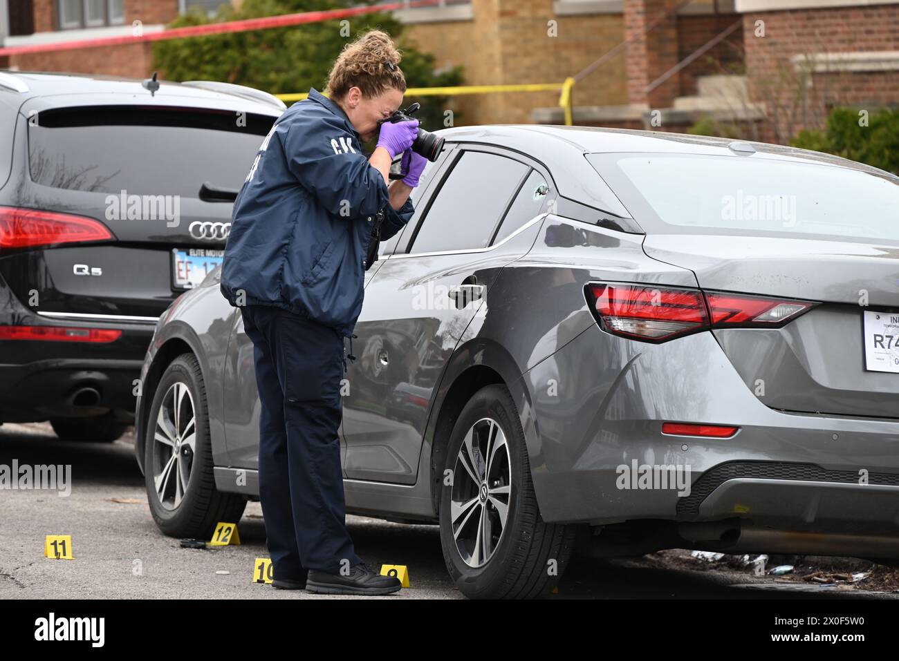 Chicago police officer takes photos of shell casings on the ground, a ...