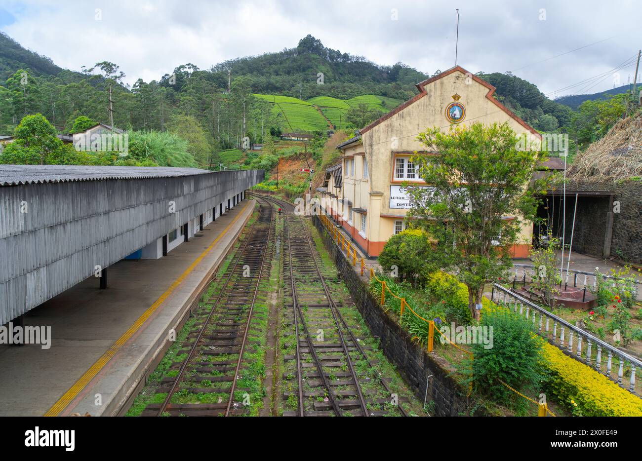A tranquil railway station, with empty tracks leading the eye towards ...