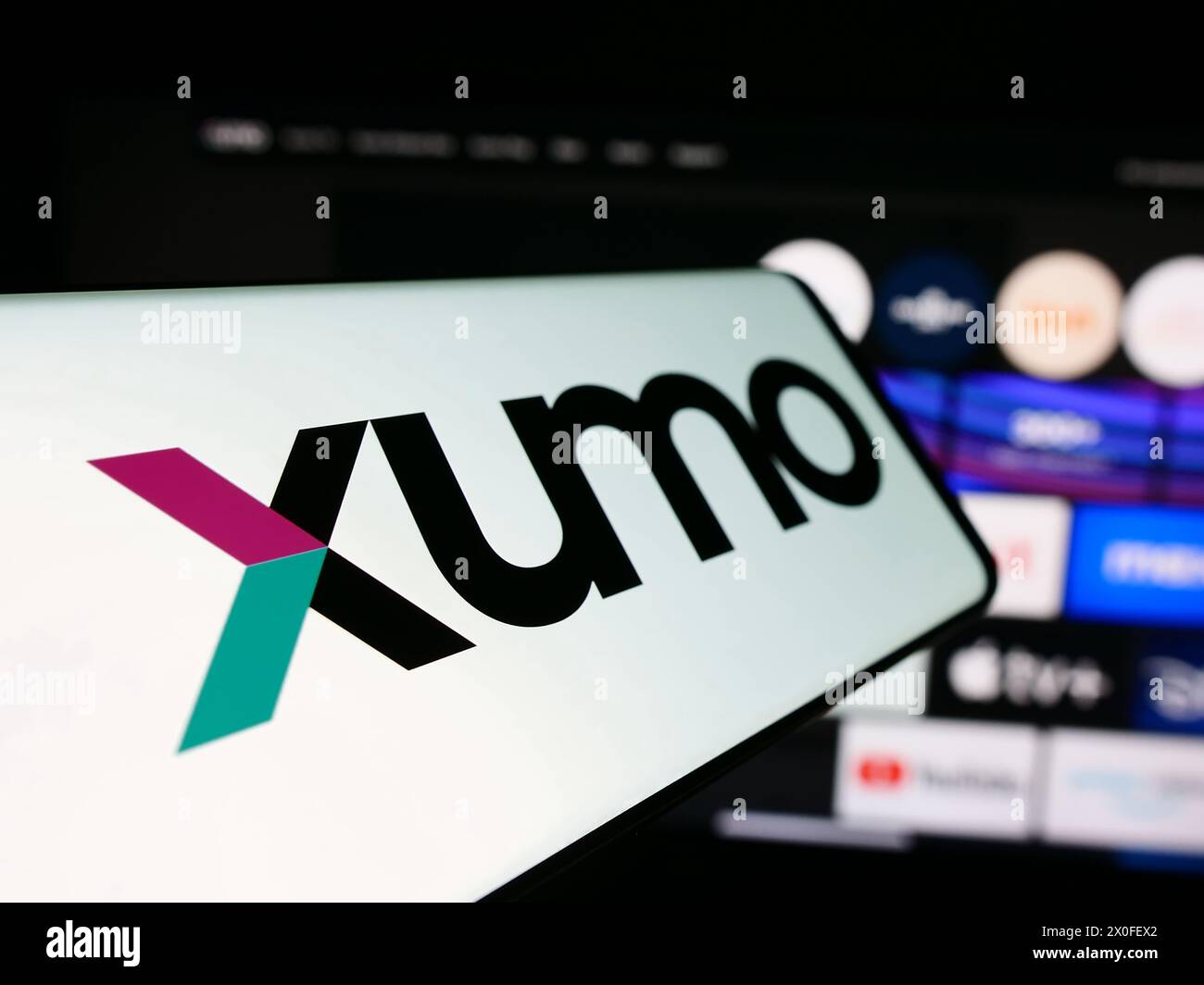 Mobile phone with logo of American video and television streaming company Xumo LLC in front of business website. Focus on left of phone display. Stock Photo