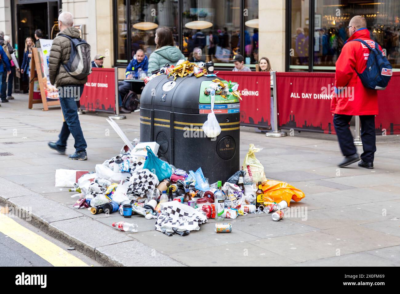 Full litter bin overflowing with rubbish in Central London, Westminster, London, England Stock Photo