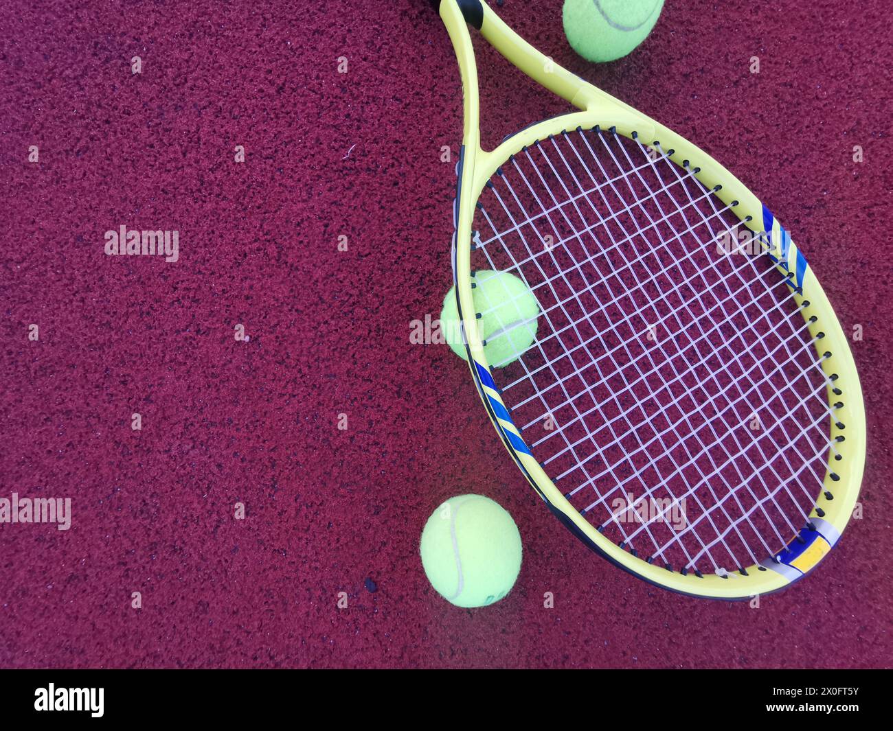 yellow tennis balls and racquet on hard tennis court surface, top view ...