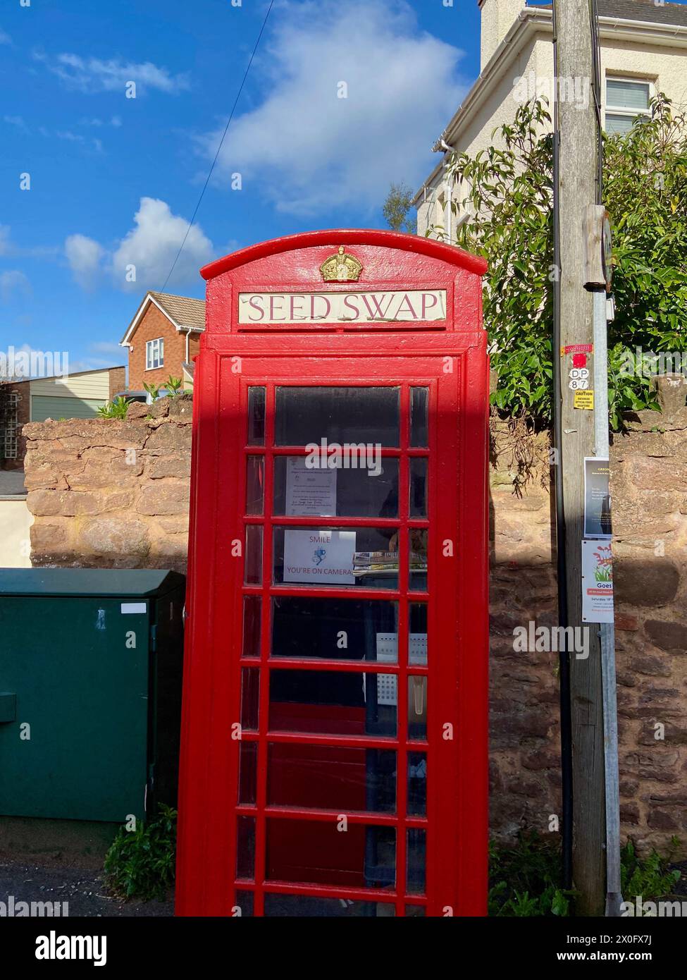 a classic K2 british red telephone kiosk being reused as a seed swap in