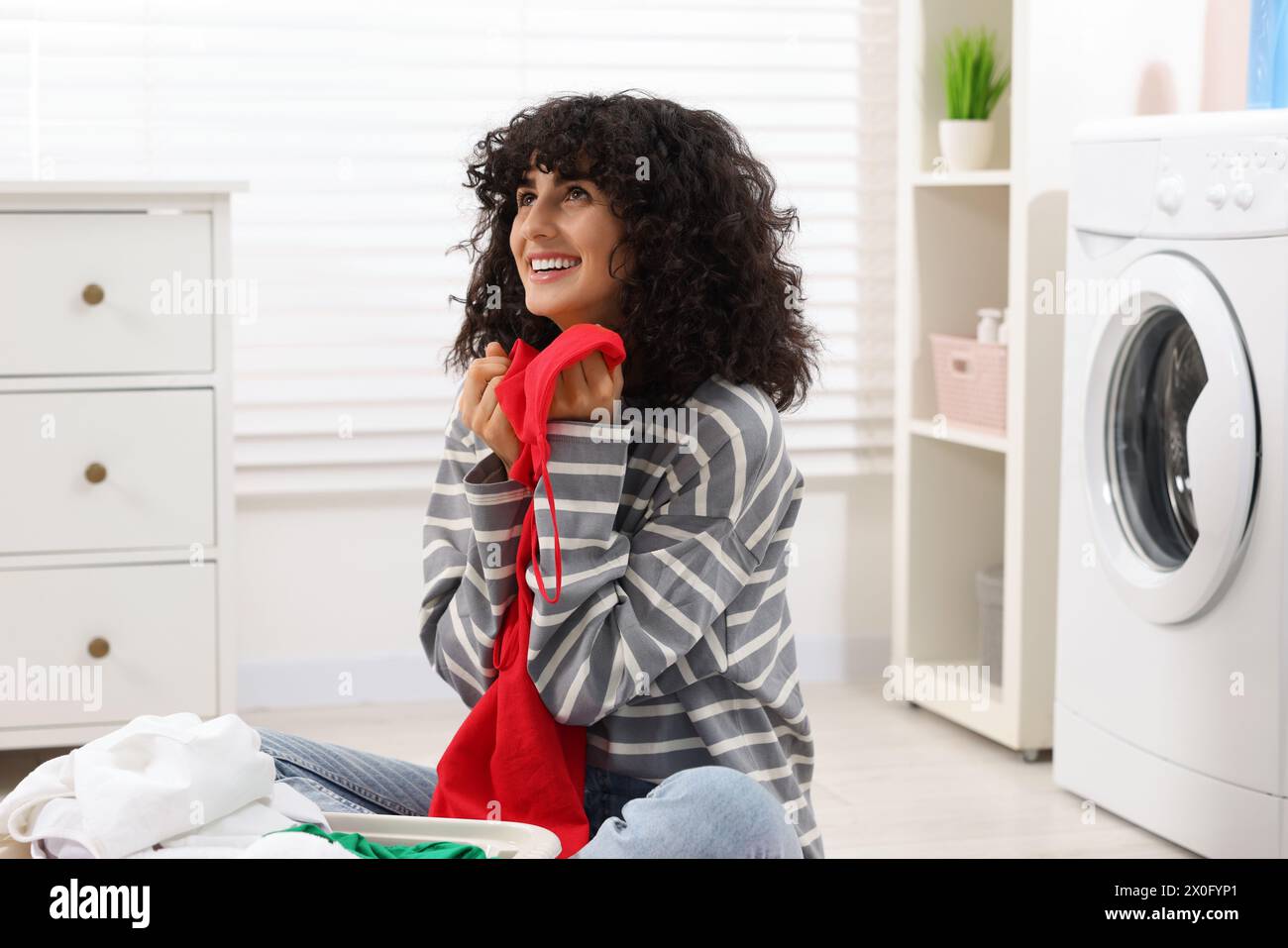 Beautiful woman with clean laundry at home Stock Photo