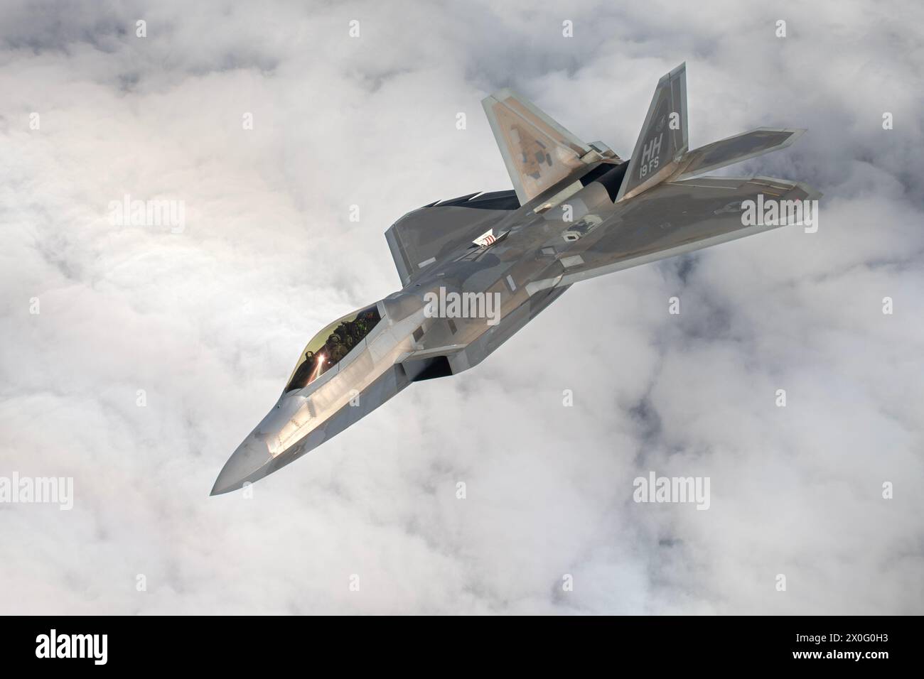 An F-22A Raptor assigned to the 19th Fighter Squadron, Joint Base Pearl Harbor–Hickam, Hawaii, departs after receiving aerial refueling during a large Stock Photo