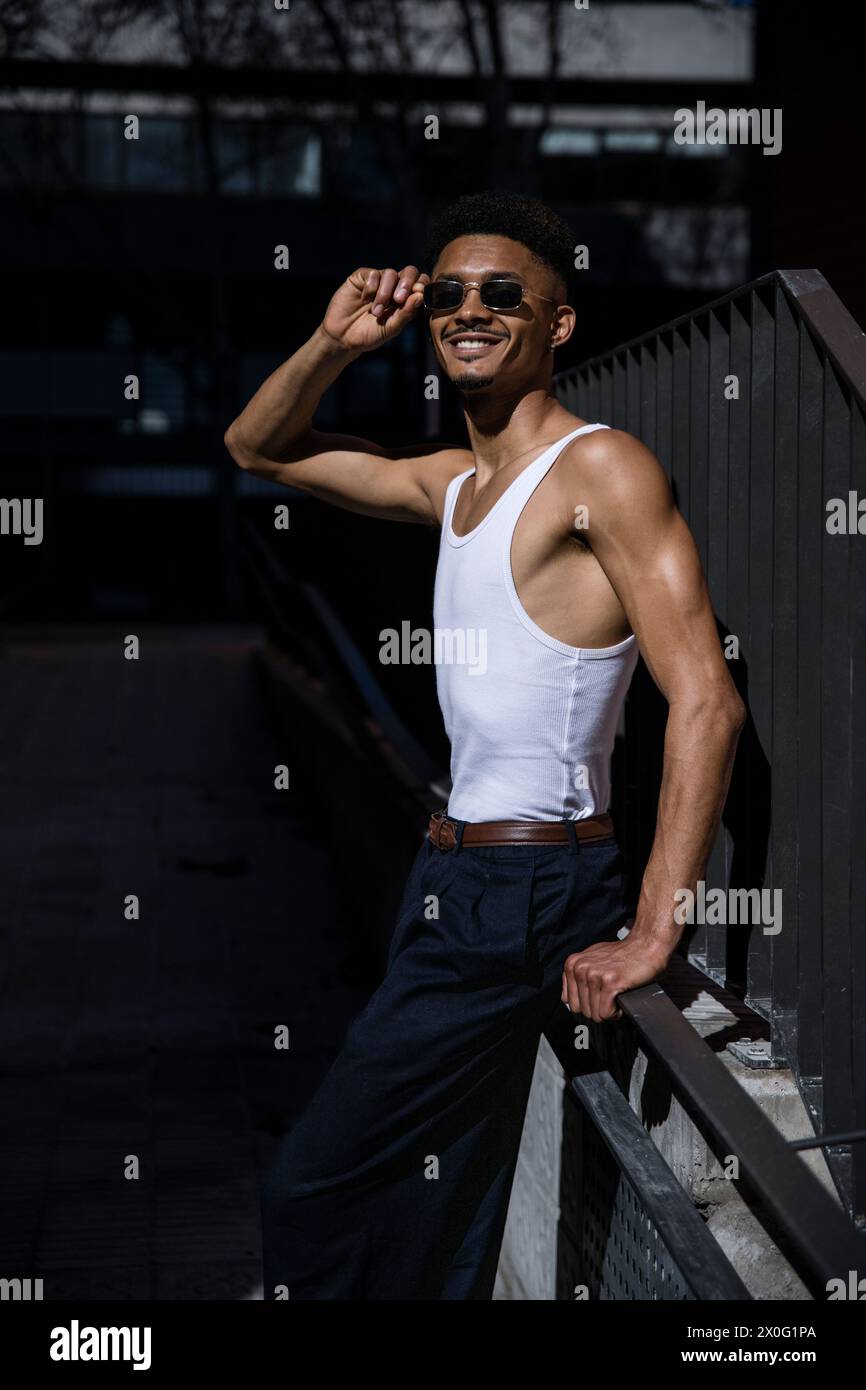 Handsome confident man leaning against a wall looking at camera. Stock Photo