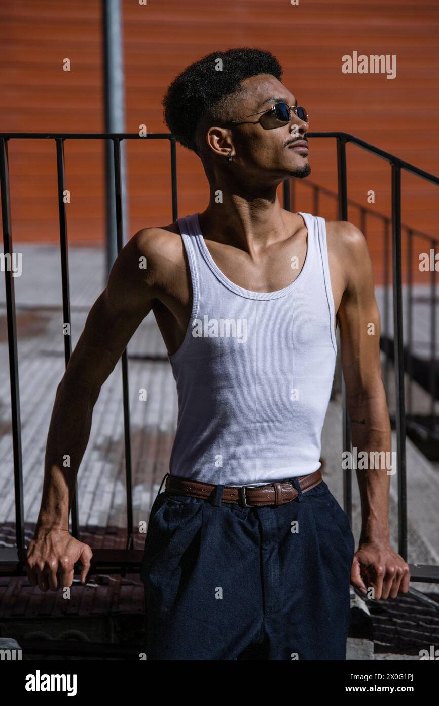 Relaxed happy guy leaning against a handrail in the sun. Stock Photo