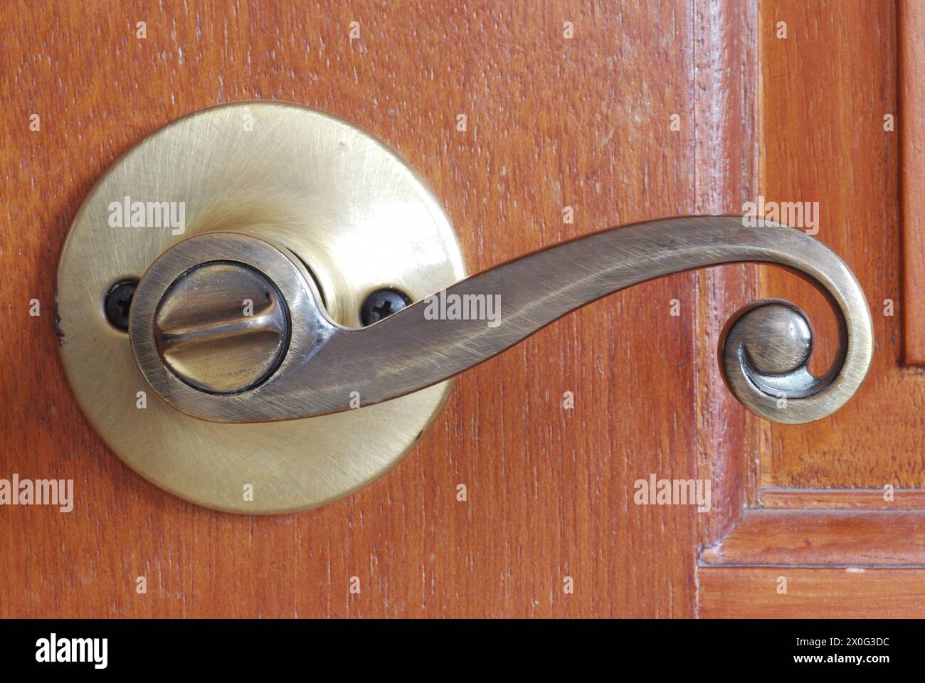 artistic bronze doorknob against wooden door Stock Photo