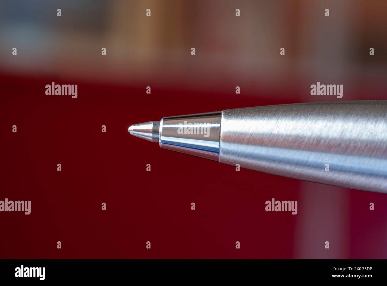 Silver ballpen against bokeh of office with red cubicle Stock Photo