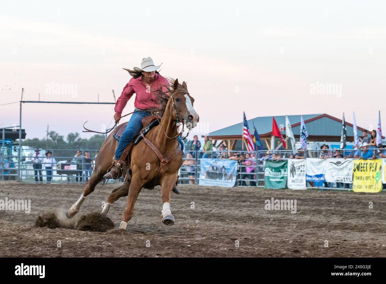 Cowgirl racing horse at county fair rodeo Stock Photo