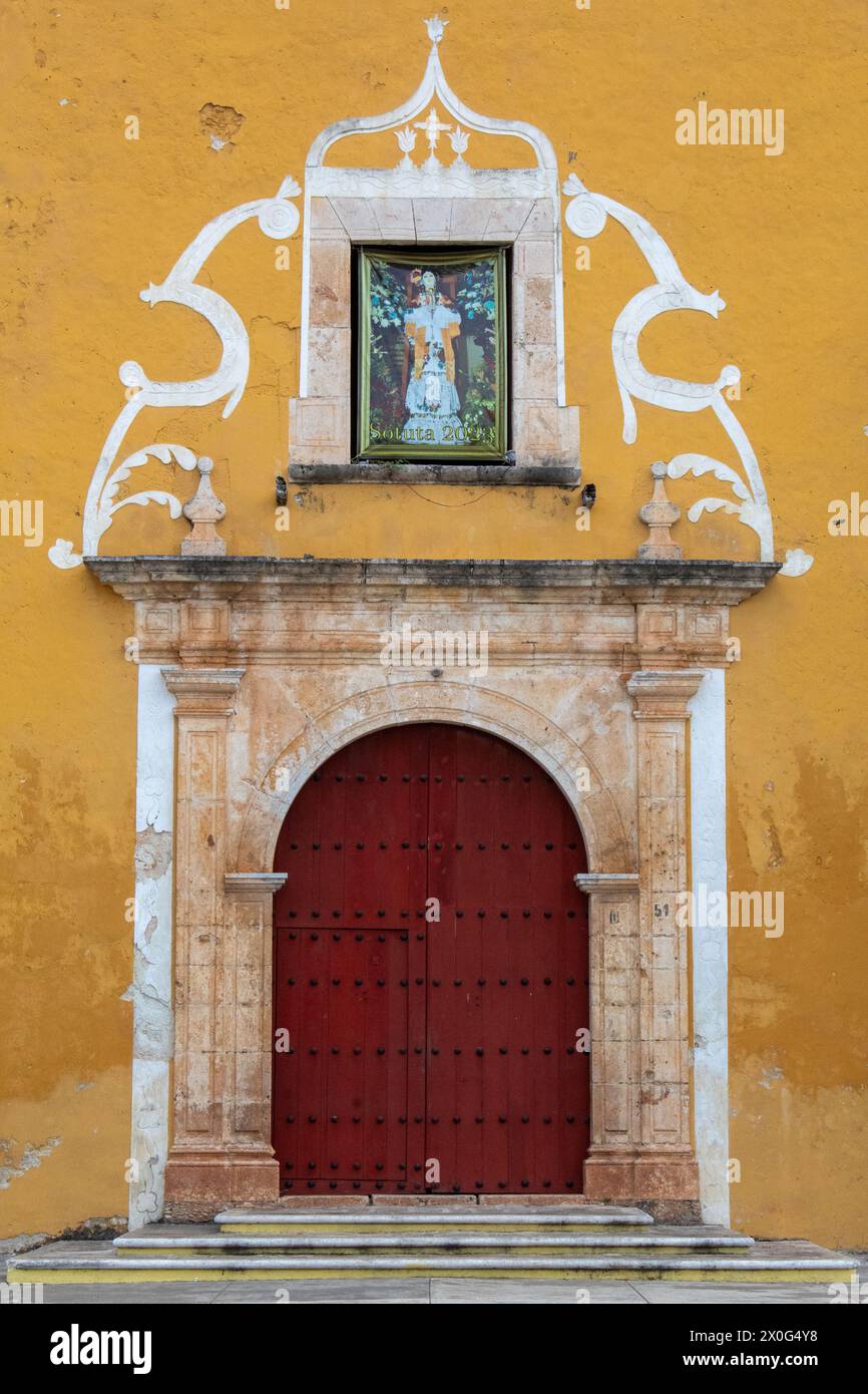 Red door of a yellow-colored old building Stock Photo