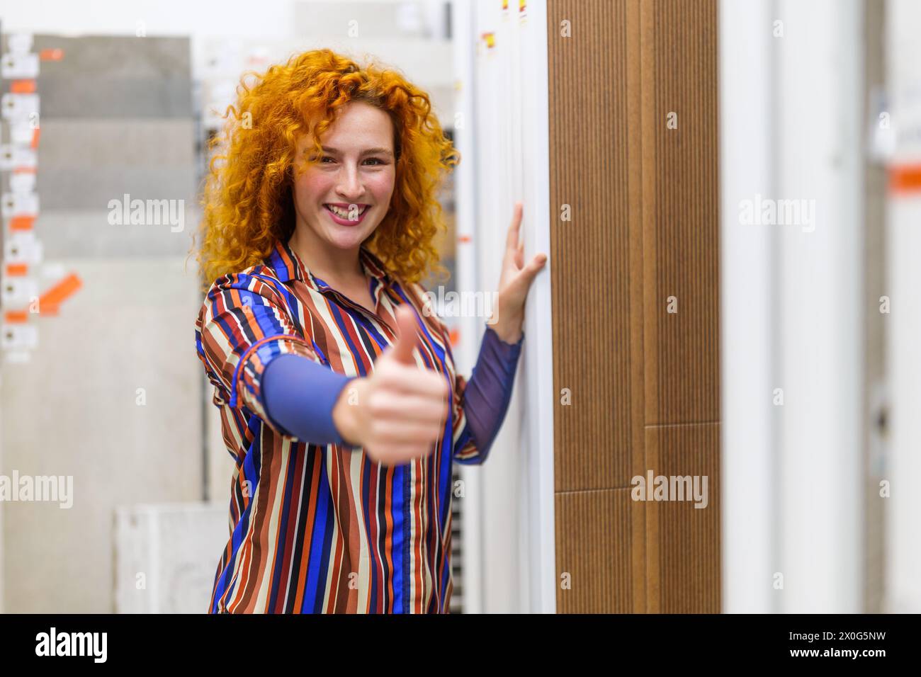 Portrait of salesperson in bathroom store. Happy redhead woman works in bath store. Sales occupation. Stock Photo