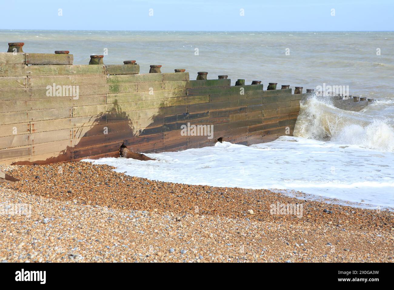 Wooden breakwater or groyne with waves from English Channel breaking with spray Stock Photo