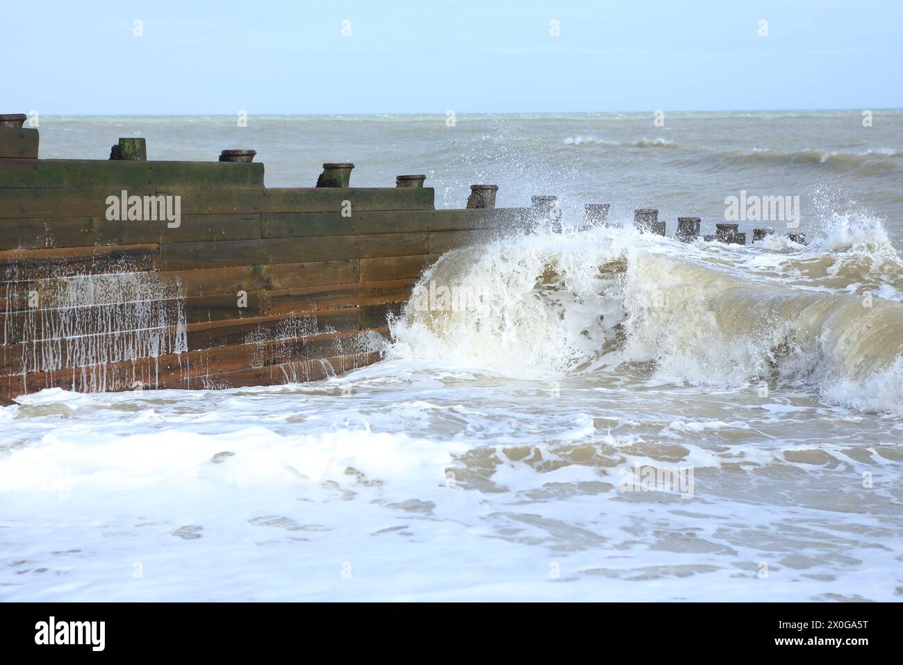 Wooden breakwater or groyne with waves from English Channel breaking with spray Stock Photo