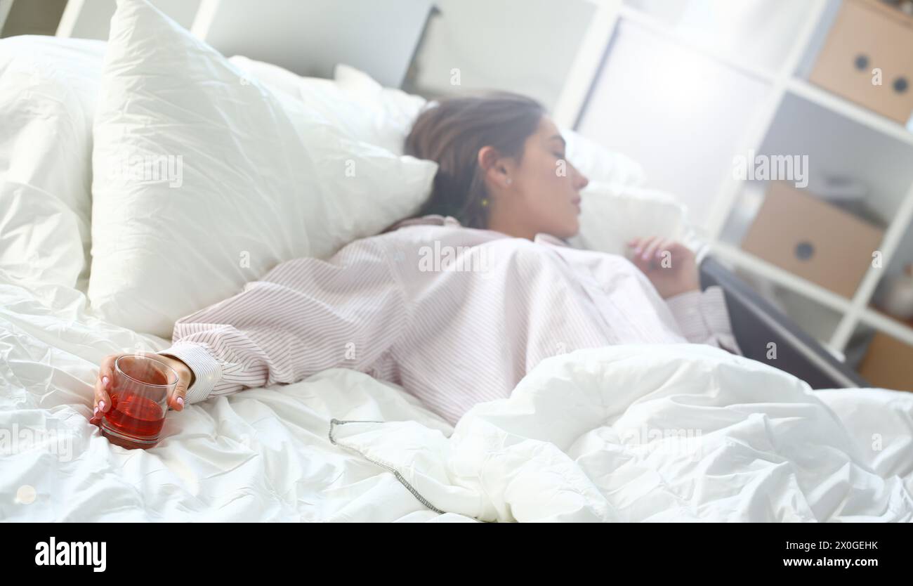 Young woman lying in bed deadly drunken Stock Photo