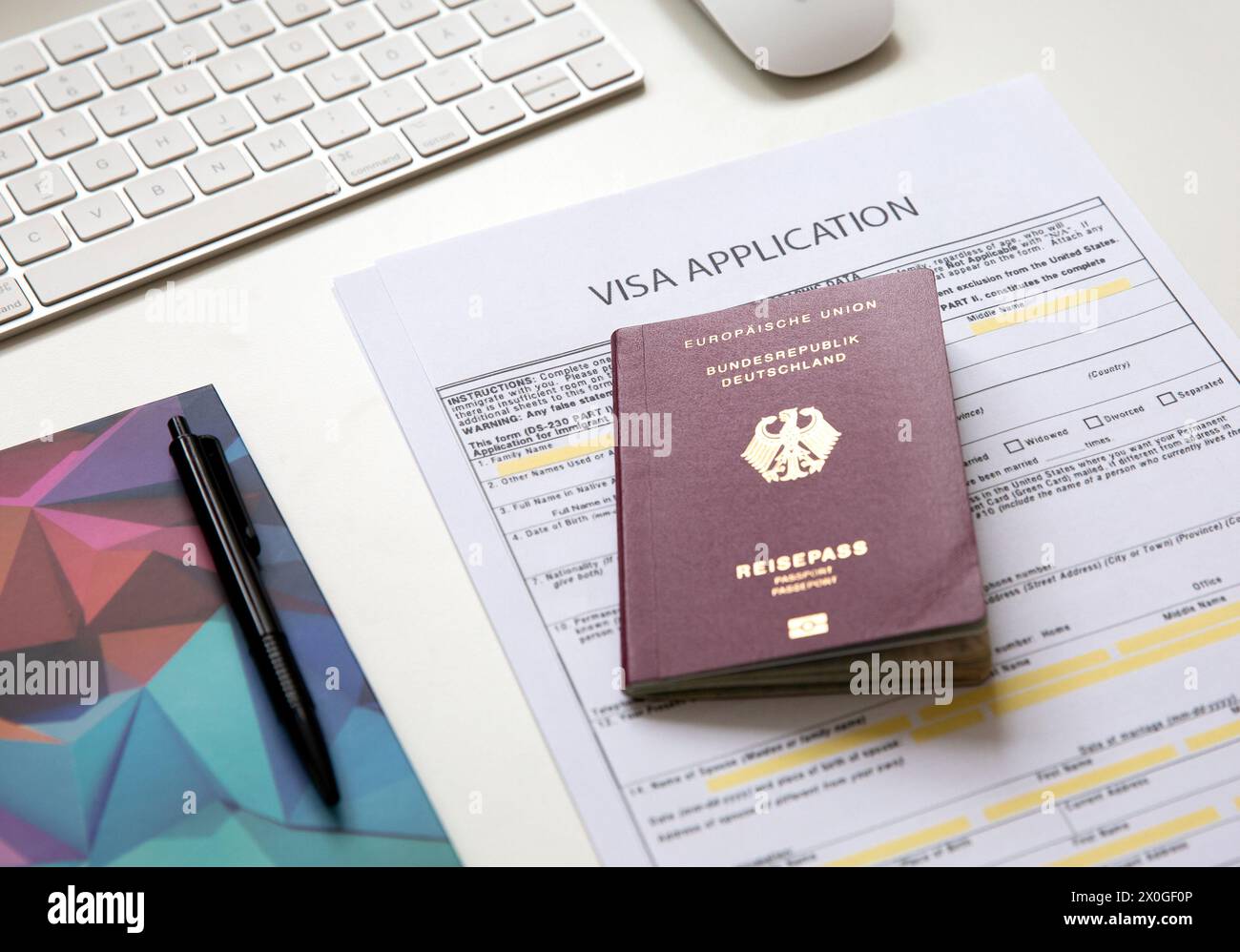 Top view of a visa application document with a German passport on table Stock Photo