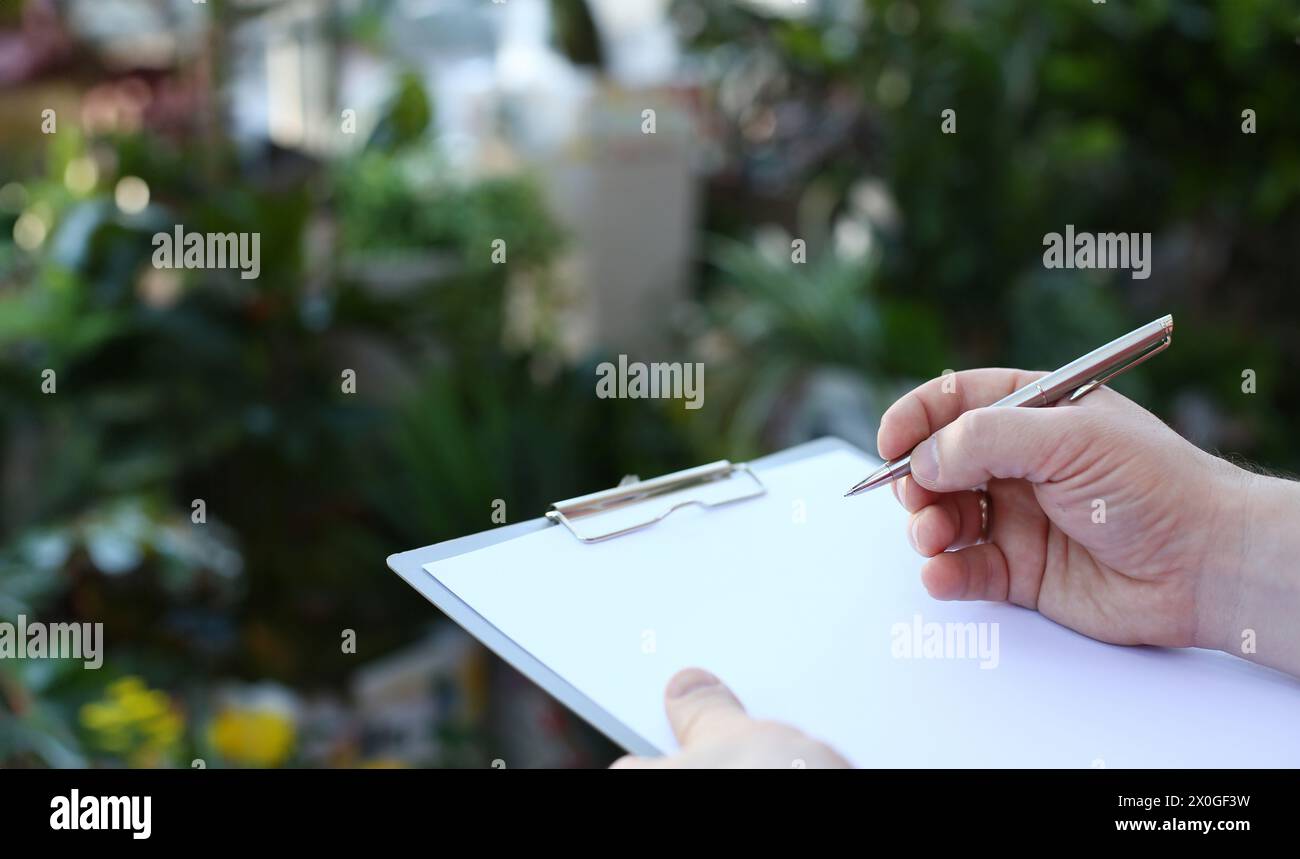 Human Hand Writing on Clipboard with White Paper Stock Photo - Alamy