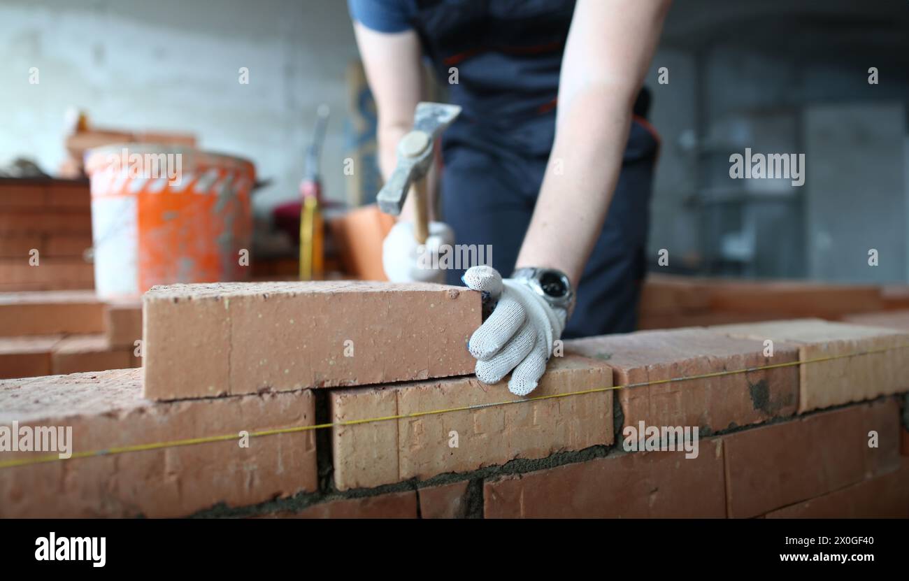 Skilled bricklayer putting red block Stock Photo