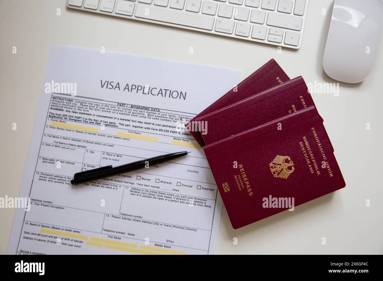 Close up of a visa application document with a German passport on table Stock Photo