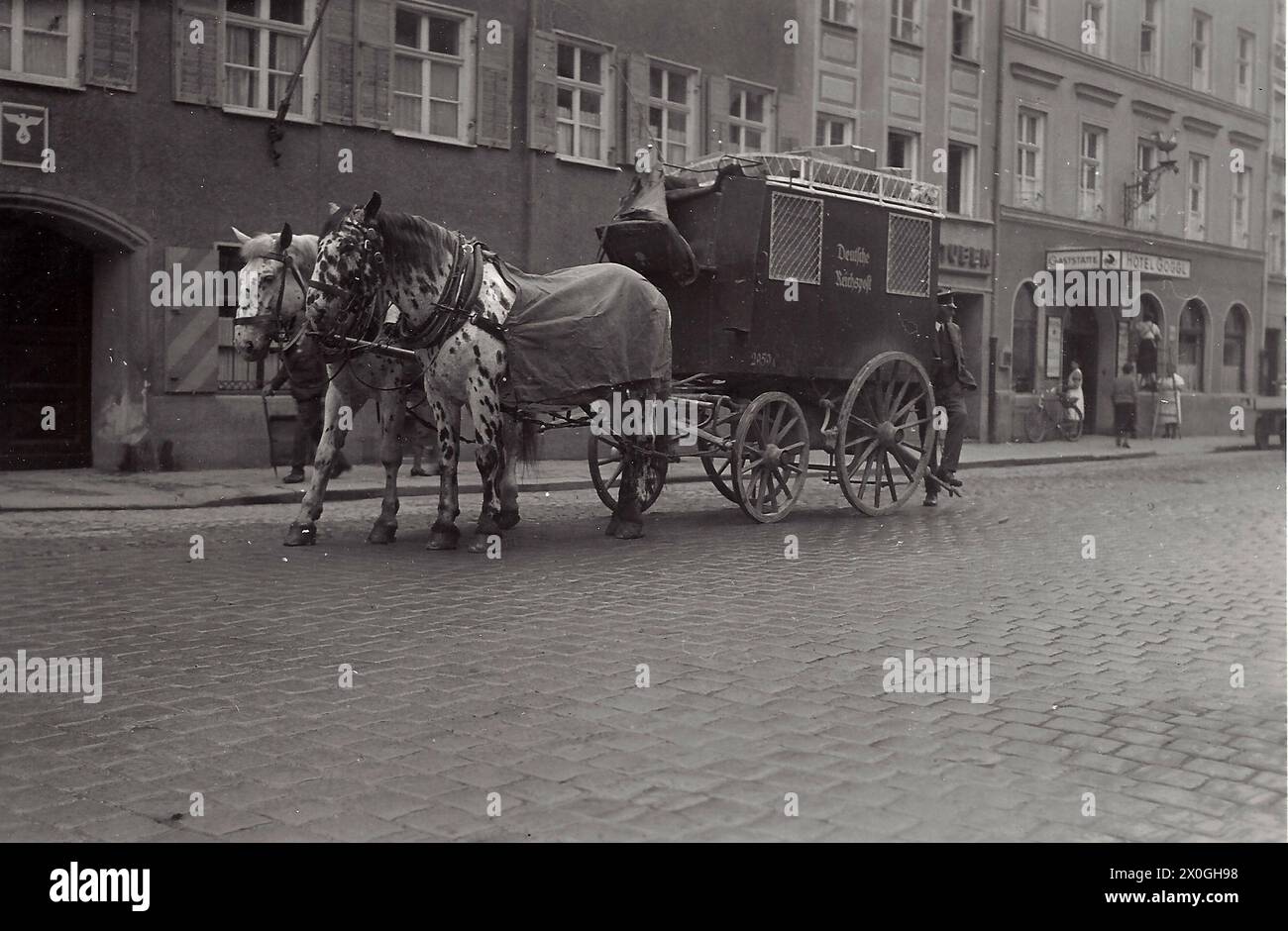 a stagecoach pulled by 2 white horses stands in front of the Hotel Goggl in Landsberg [automated translation] Stock Photo