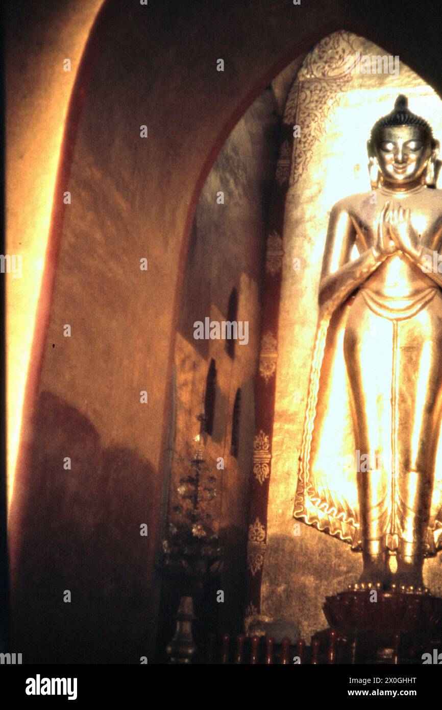 The golden statue of a Buddha inside the Ananda temple in Bagan ...