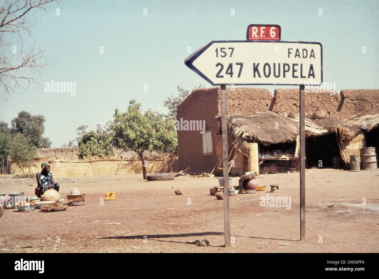 A road sign in Rapadama shows the direction and distance to Koupela and Fada. [automated translation] Stock Photo