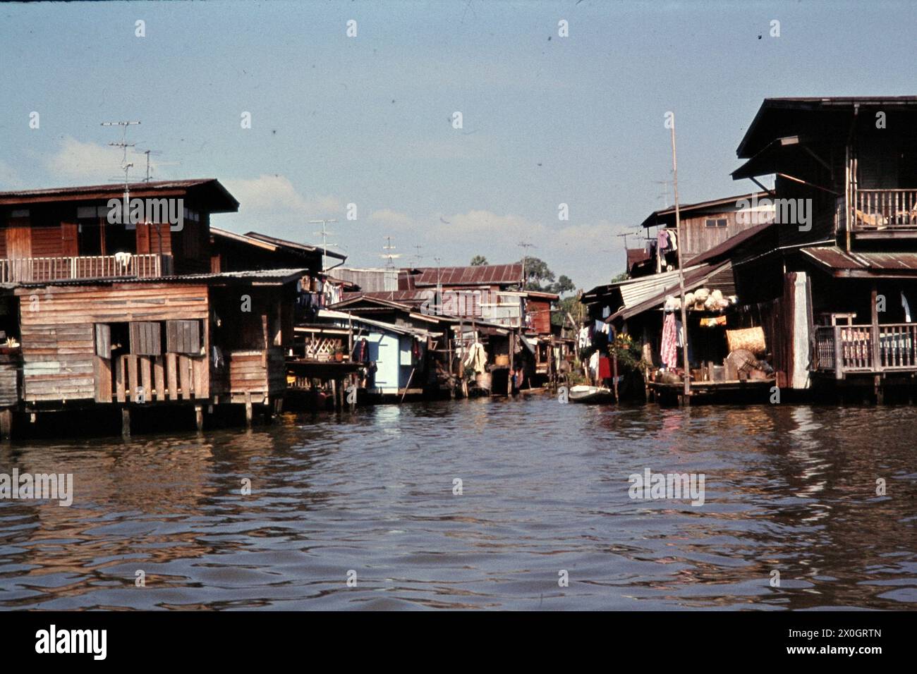 View of the entrance to a side khlong with houses made of corrugated