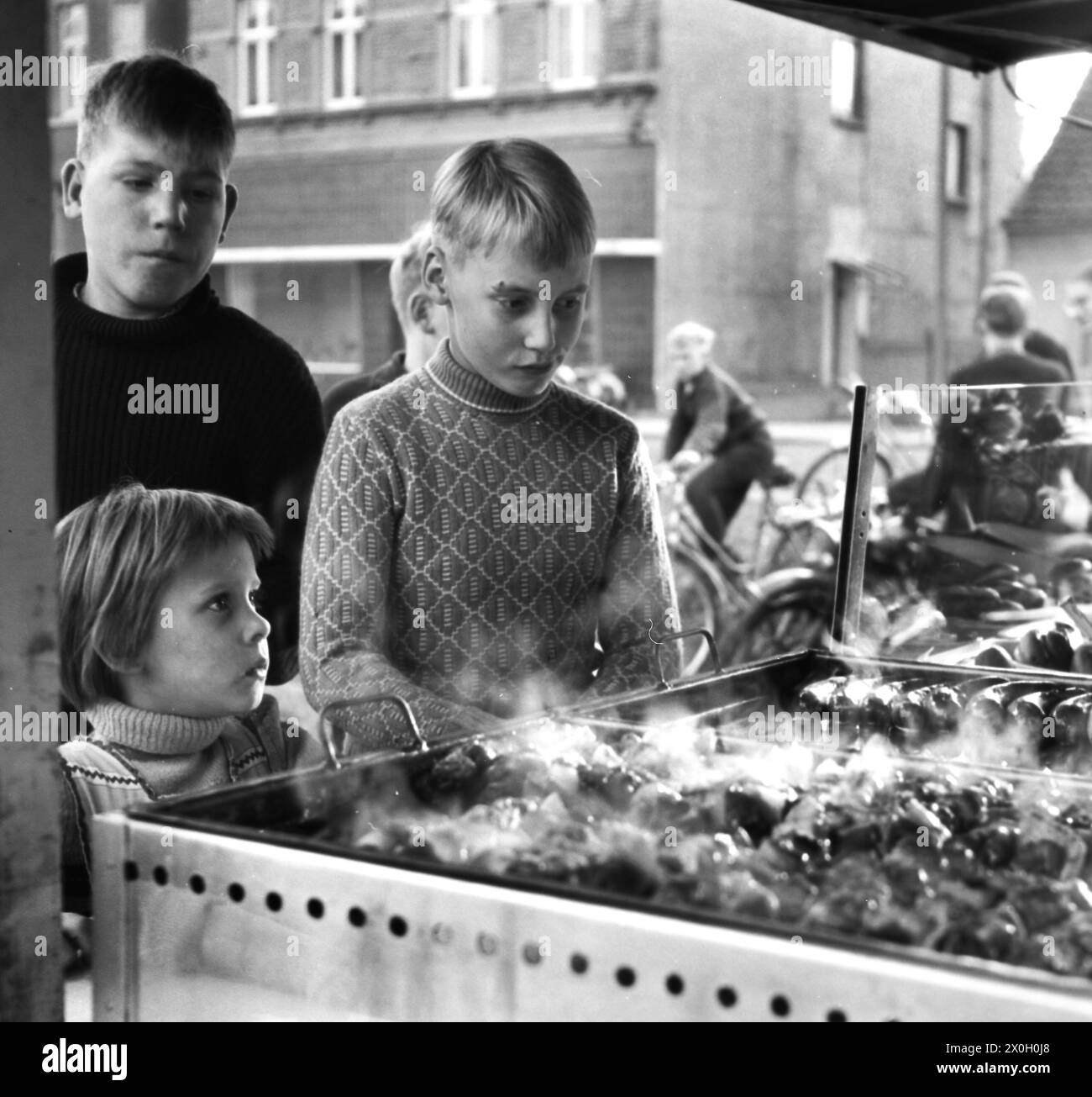 Children stand in line in front of a stall waiting for their food. [automated translation] Stock