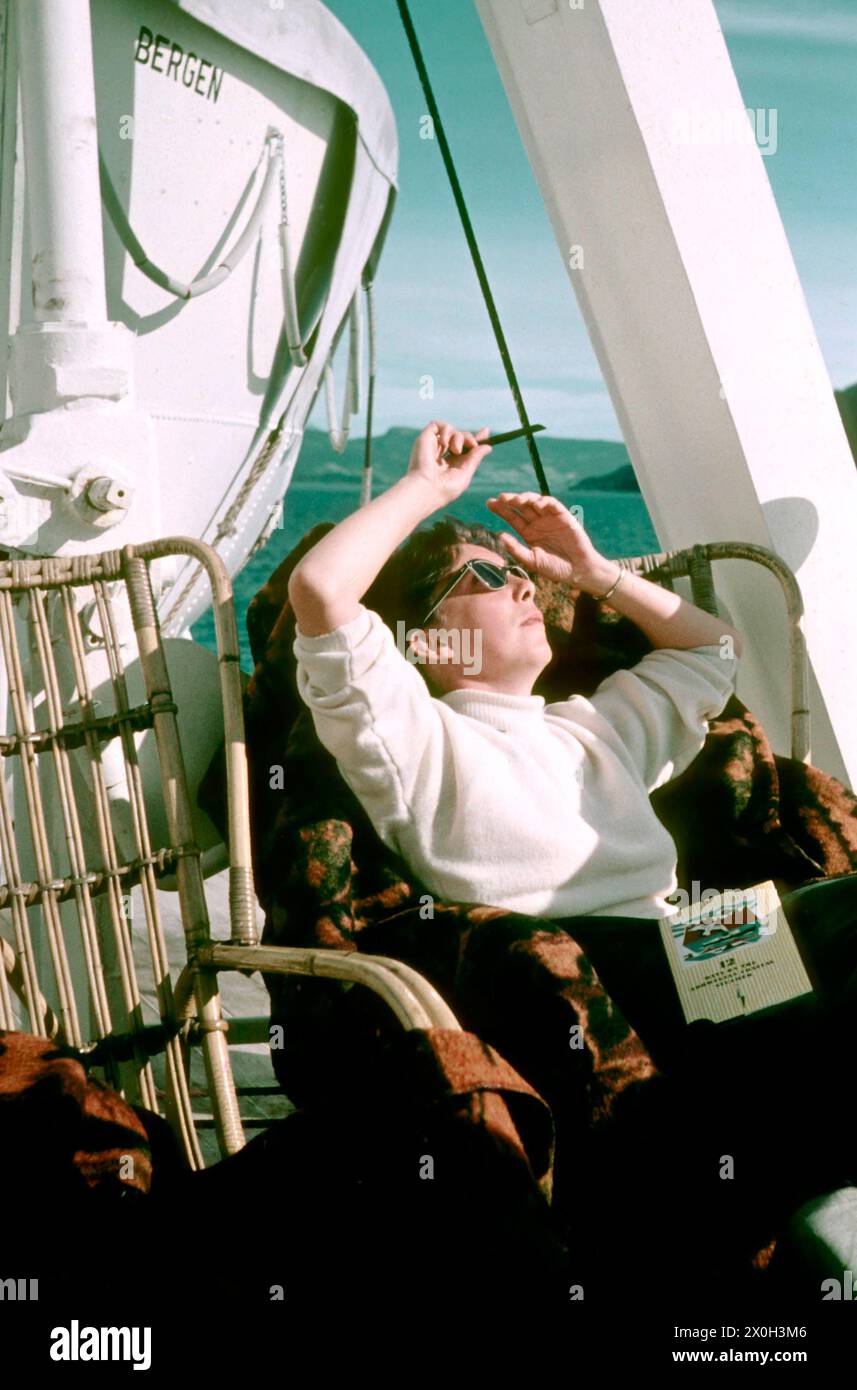 Woman is sunbathing on a liner on its way to the North Cape. Stock Photo
