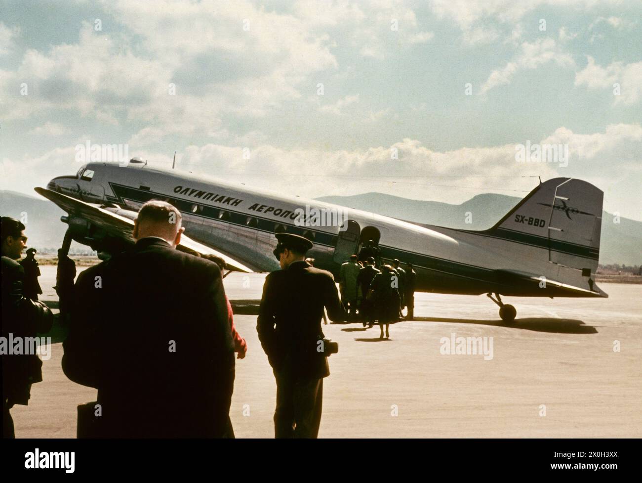 Passengers approaching a propeller plane on the tarmac of Istanbul