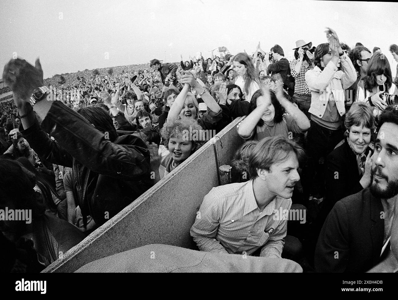 Enthusiastic and clapping audience at a concert on the Zeppelin Field in Nuremberg. The audience area is divided by barriers. [automated translation] Stock Photo