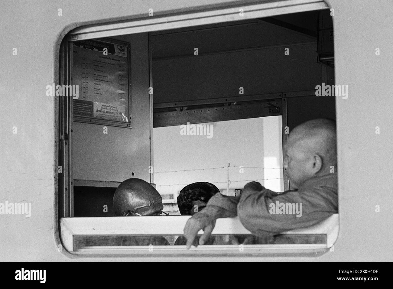 At Surat Thani station in Thailand: the senior citizens sit in the compartment with Buddhist serenity. [automated translation] Stock Photo