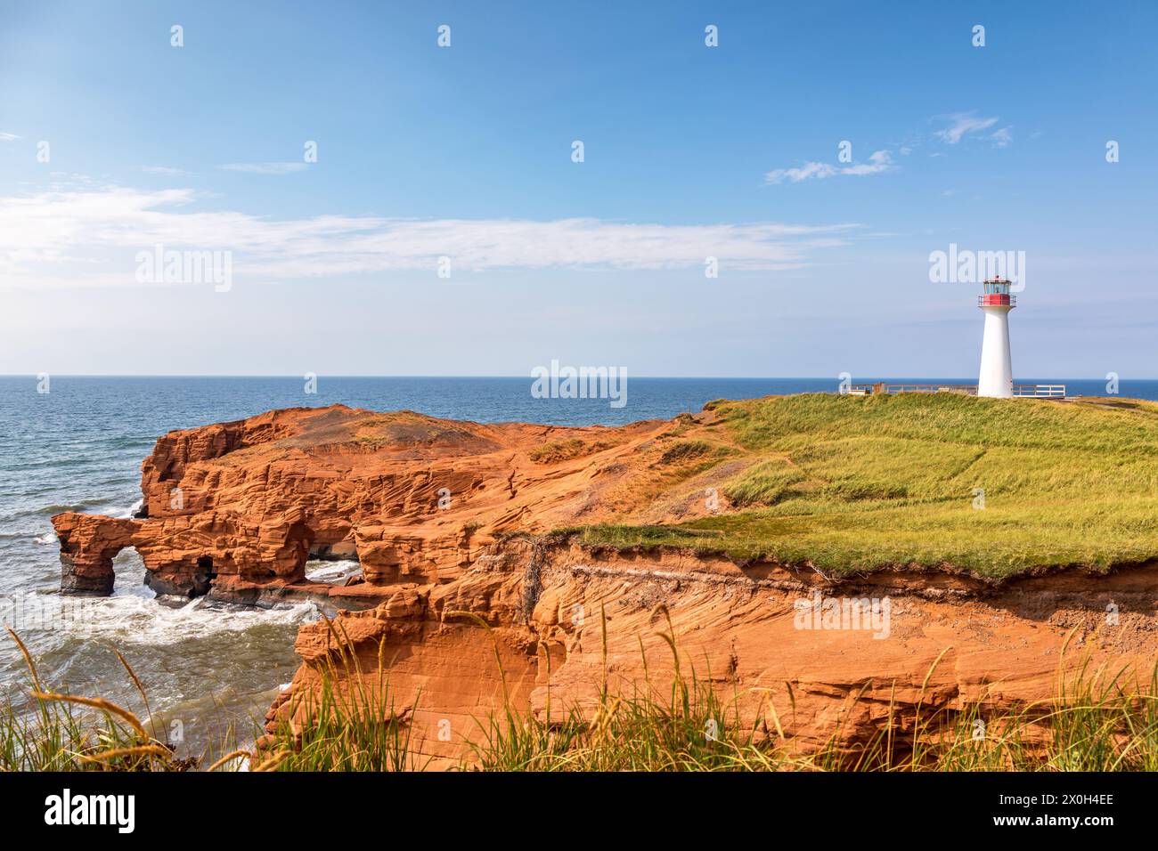 Borgot, or Cape Herisse lighthouse of Cap aux Meules, Magdalen Islands, Canada. The lighthouse stands on the rugged red cliffs of the Etang du Nord. Stock Photo
