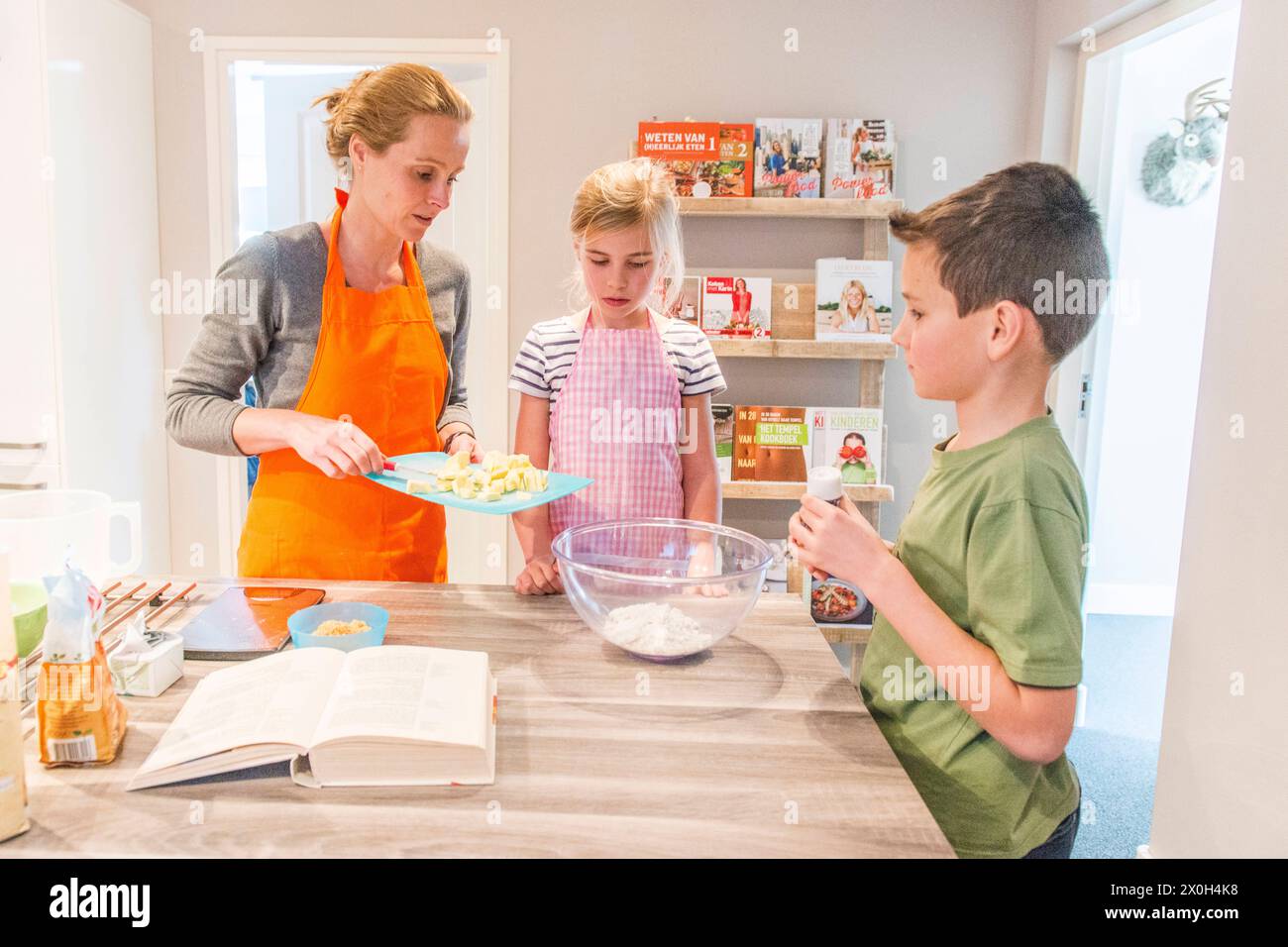Housewife and Mother Baking Cookies Kaatsheuvel, Netherlands. Mid adult caucasian mother and her son and daughter baking cookies on a friday afternoon. MRYES for Mother & Daughter, not for Son-Boy Kaatsheuvel Hoofdstaat Noord-Brabant Nederland Copyright: xGuidoxKoppesxPhotox Stock Photo