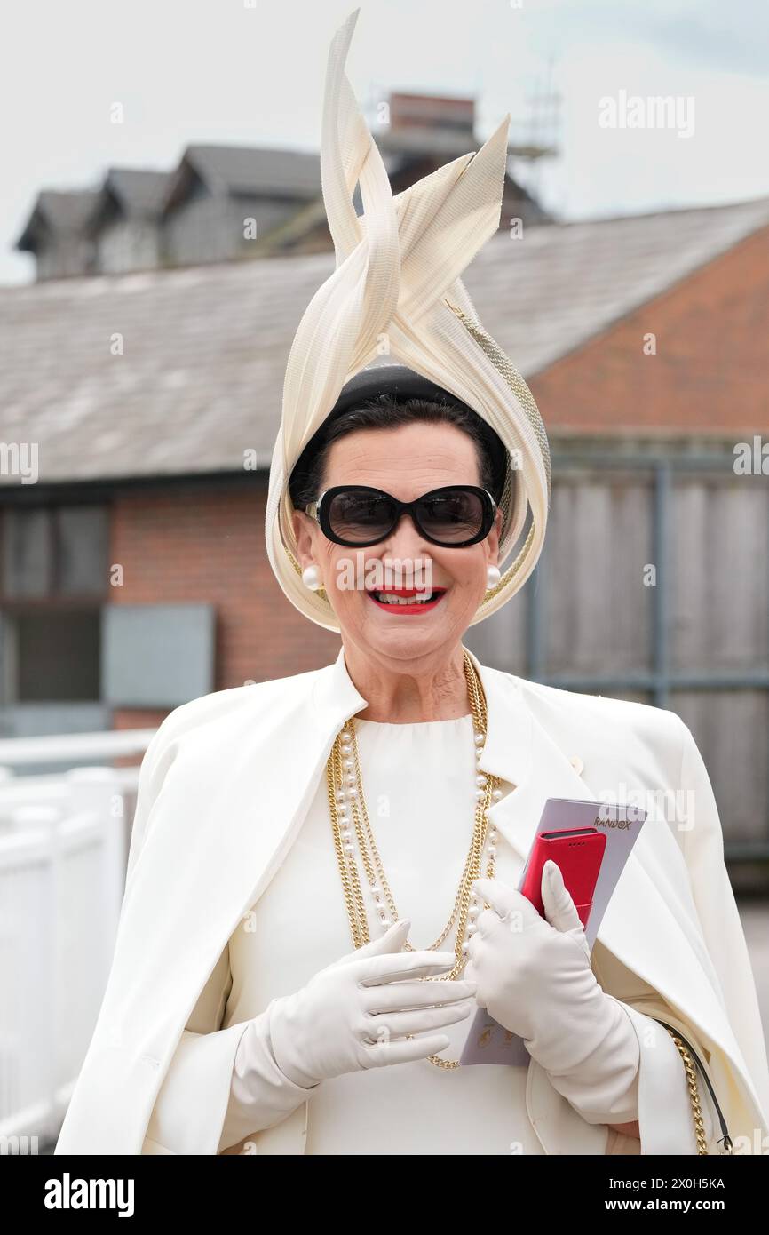 Aintree Racecourse, Aintree, Merseyside, England. 12th April 2024.  2024 Grand National Festival Day 2; A Race goer poses for a photo during Ladies Day, day 2 of the festival.Photo credit: Stephen Hearn/Action Plus Sports Images/ Alamy Live News Stock Photo