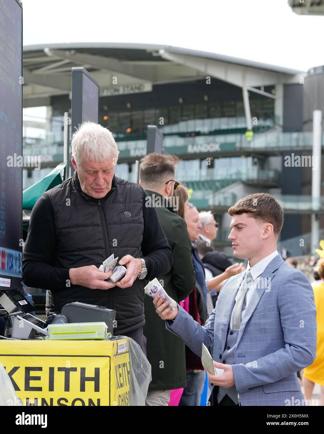 Aintree Racecourse, Aintree, Merseyside, England. 12th April 2024.  2024 Grand National Festival Day 2; A punter paces a bet during Ladies Day, day 2 of the festival.Photo credit: Stephen Hearn/Action Plus Sports Images/ Alamy Live News Stock Photo