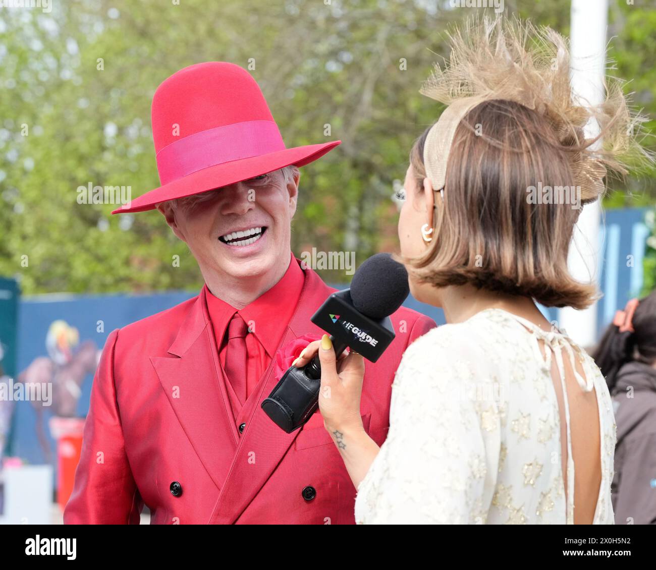 Aintree Racecourse, Aintree, Merseyside, England. 12th April 2024.  2024 Grand National Festival Day 2; A flamboyantly dressed race goer is interviewed during Ladies Day, day 2 of the festival.Photo credit: Stephen Hearn/Action Plus Sports Images/ Alamy Live News Stock Photo