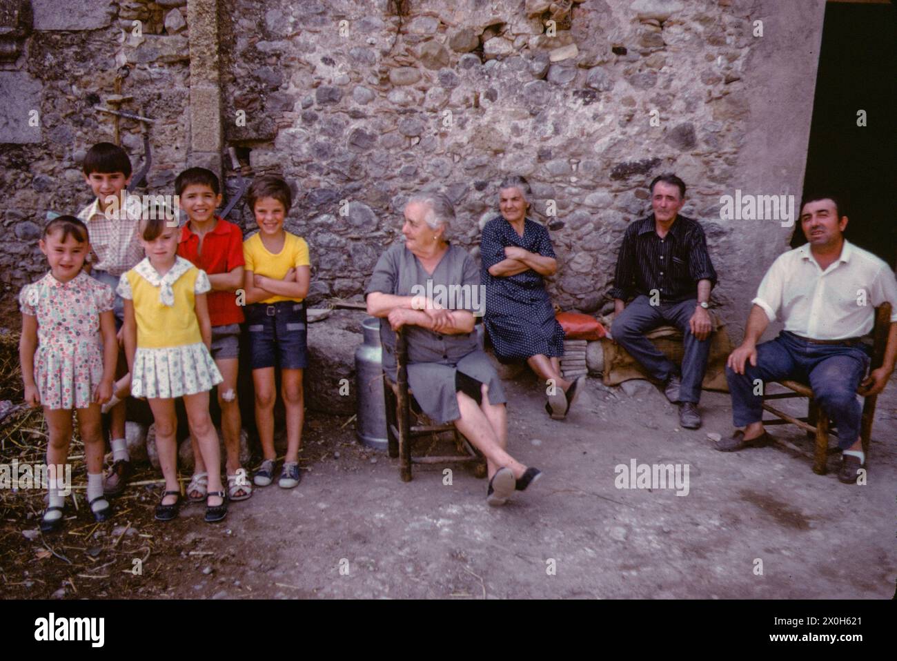 Three generations pose for a group photo in front of their house ...