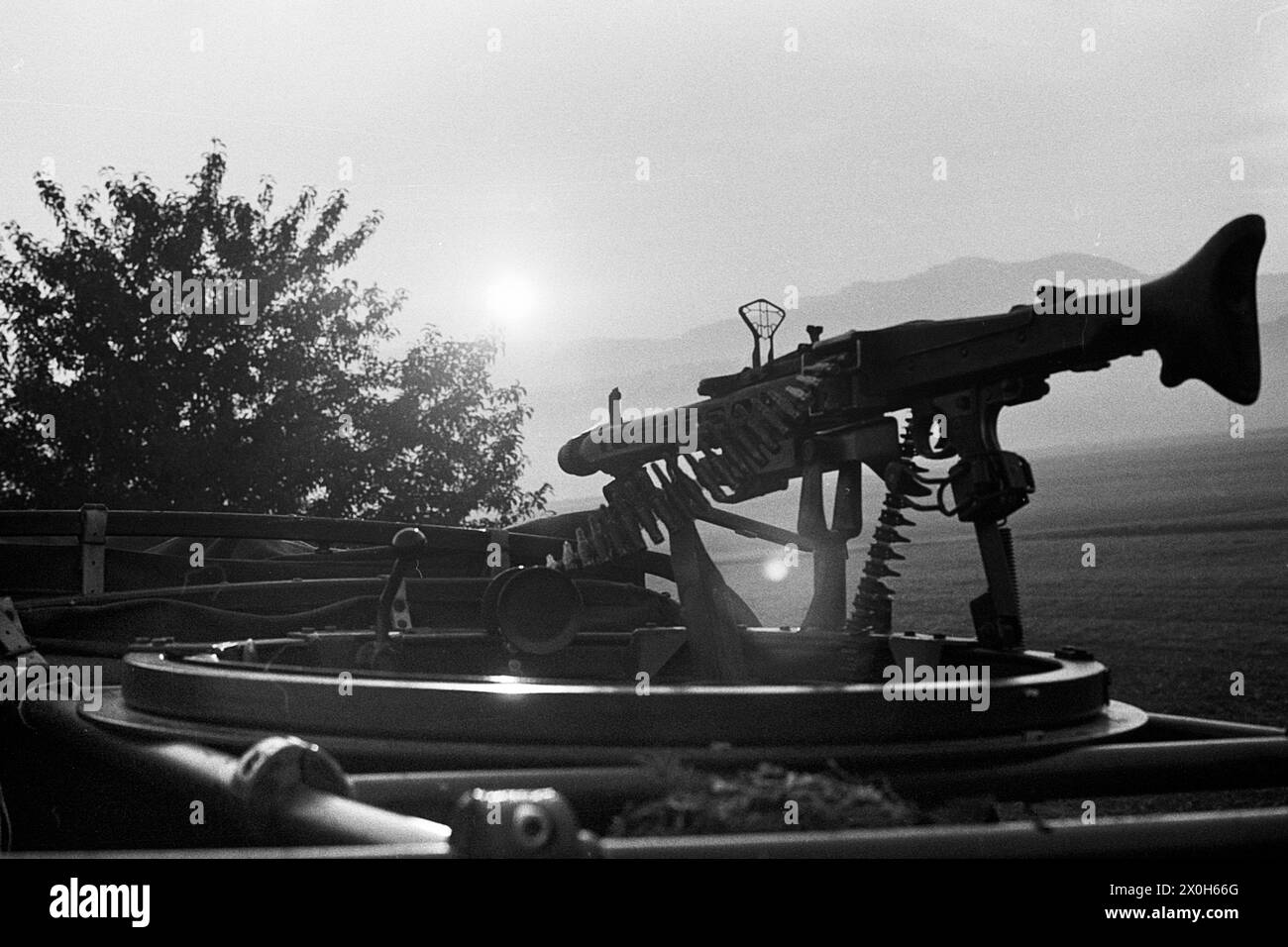 A machine gun on a Unimog in the rising sun during a Bundeswehr combat exercise. An airplane sight on the MG 3 machine gun. [automated translation] Stock Photo