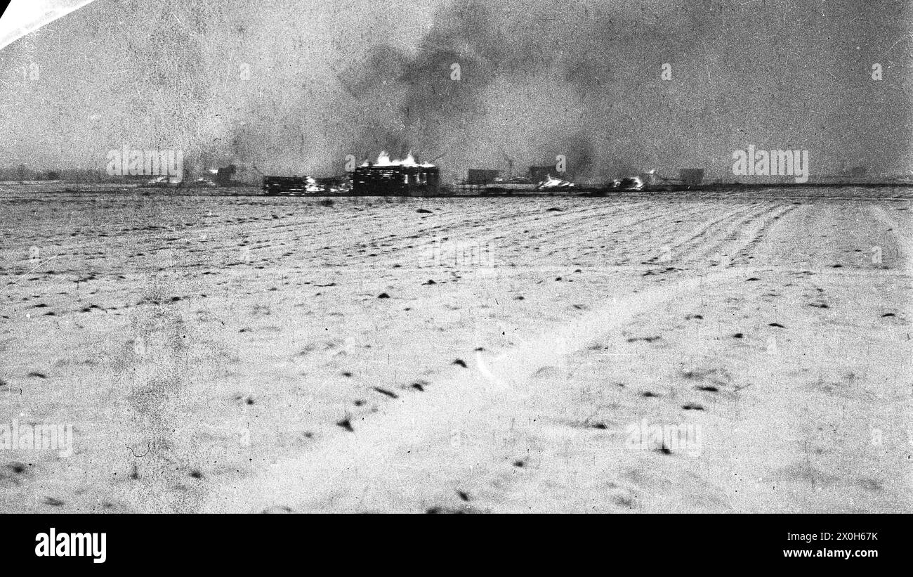 In the wintry expanse, houses in a village are burning that were set on fire by German troops fighting partisans in the hinterland of the Eastern Front. The picture was taken in the hinterland of the Eastern Front, presumably in connection with battles with partisans. The picture was taken by a member of the Raffahrgrenadier Regiment 2 / Rahdfahrsicherungsregiment 2, in the northern section of the Eastern Front. [automated translation] Stock Photo