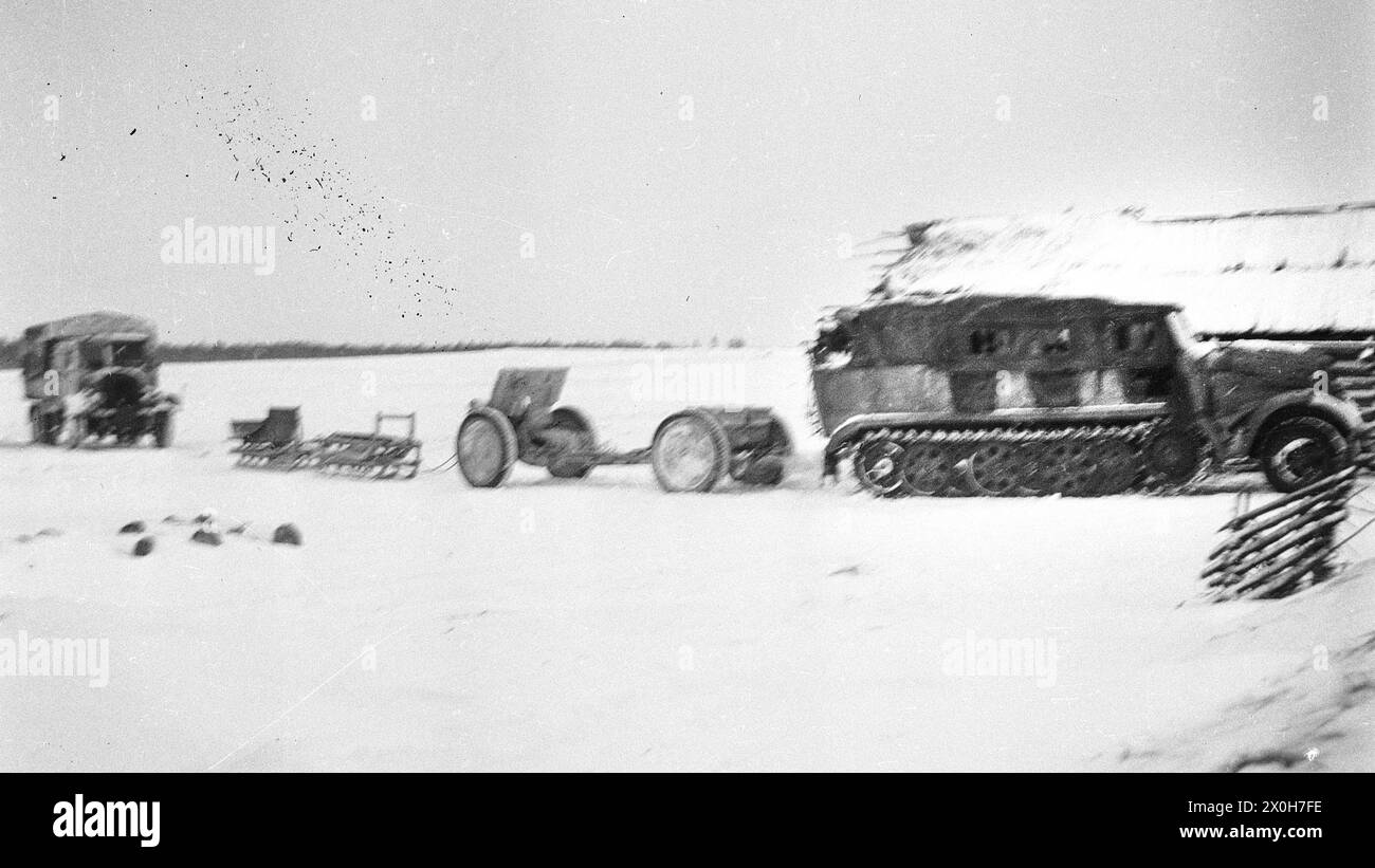 A half-track vehicle pulls an infantry gun and several sledges in a village in the rear of the Eastern Front. The picture was taken in the rear of the Eastern Front, presumably in connection with fighting with partisans. The picture was taken by a member of the Radfahrgrenadierregiment 2 / Rahdfahrsicherungsregiment 2, in the northern section of the Eastern Front. [automated translation] Stock Photo