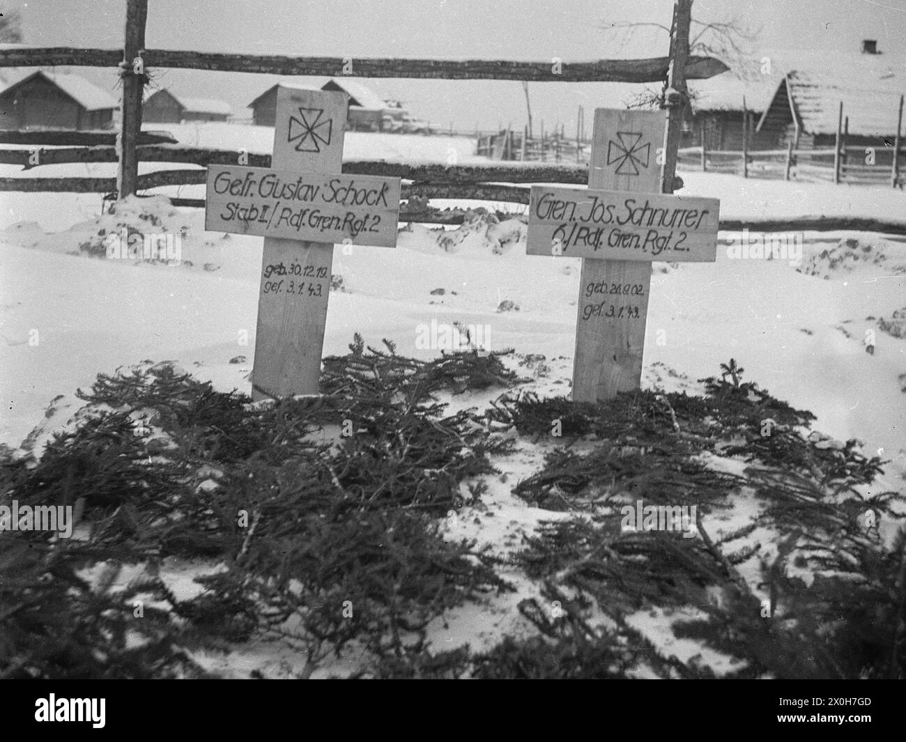 Two soldiers of the Radfahr Grenadier Regiment 2 are buried on the edge of a village. The picture was taken by a member of the Radfahrgrenadierregiment 2 / Radfahrsicherungsregiment 2, in the northern section of the Eastern Front. [automated translation] Stock Photo