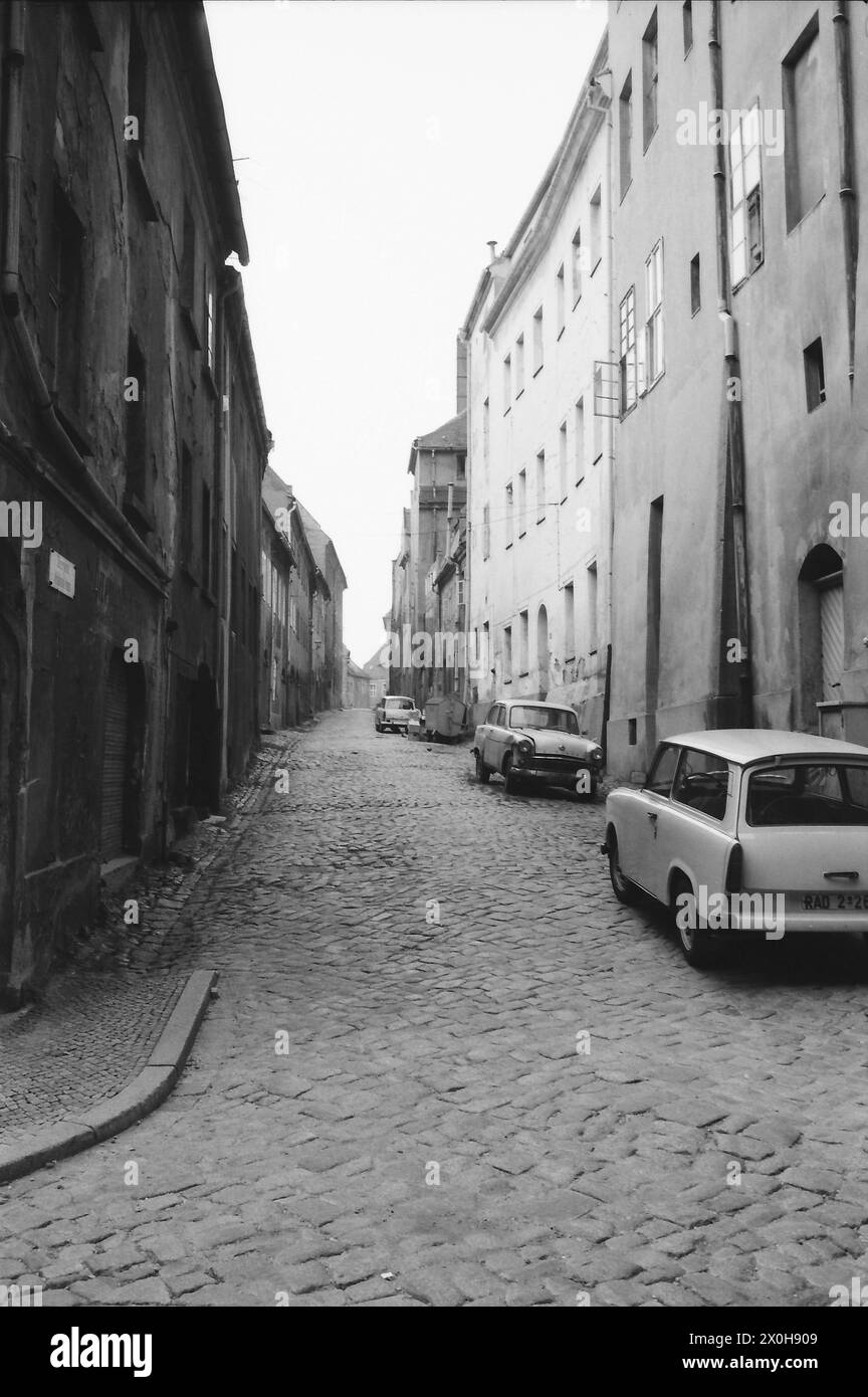 Cars are parked in a run-down alley in the East German city of Bautzen ...